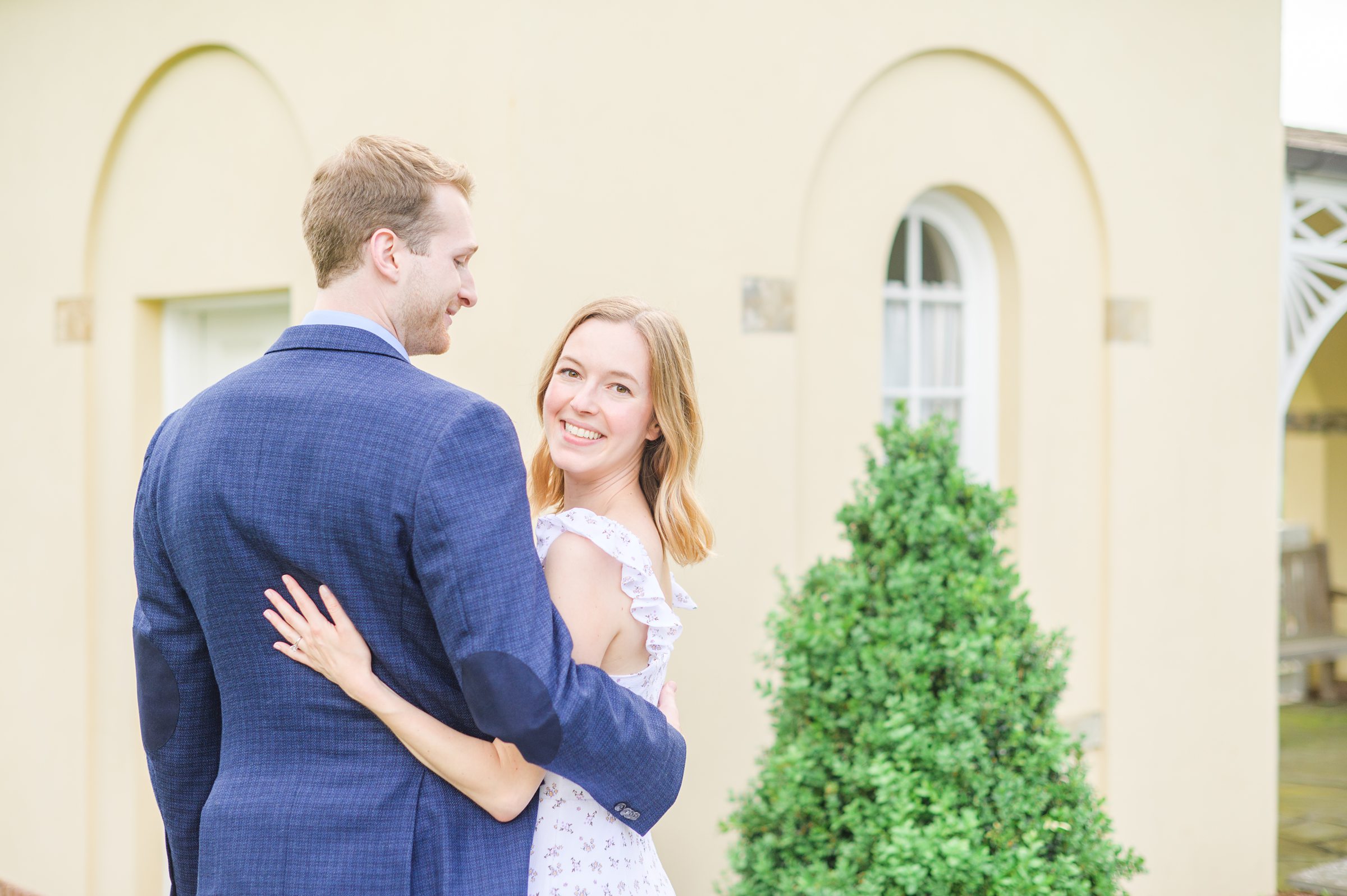 Engaged Couple smiles in the garden at Belmont Manor during a rainy sunset engagement photographed by Baltimore Wedding Photographer Cait Kramer