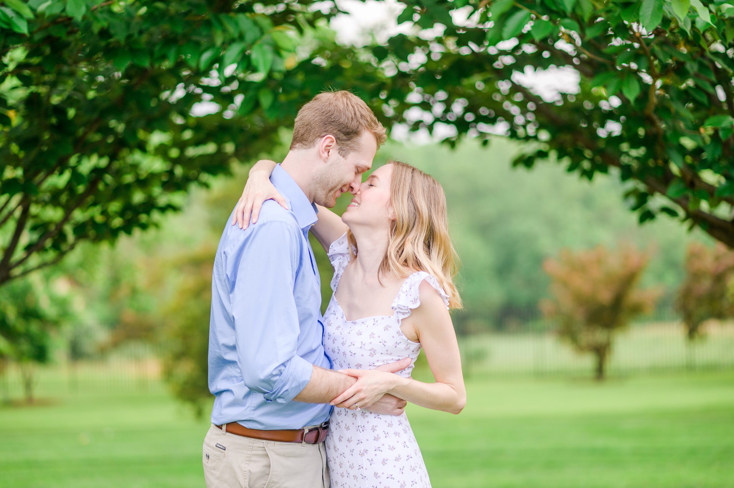 Engaged Couple smiles in the garden at Belmont Manor during a rainy sunset engagement photographed by Baltimore Wedding Photographer Cait Kramer