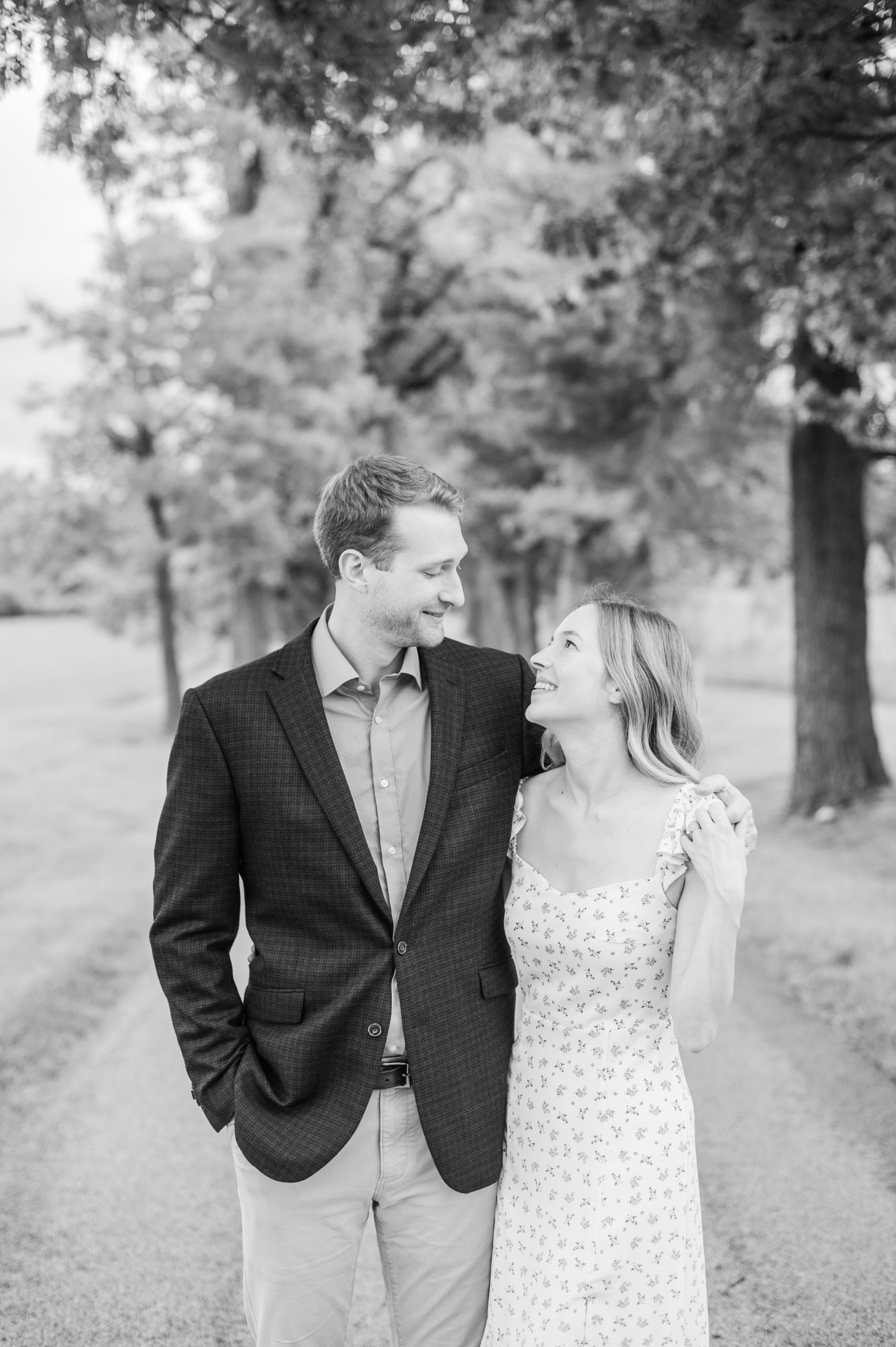 Engaged Couple poses on the treelined driveway at Belmont Manor during a rainy sunset engagement photographed by Baltimore Wedding Photographer Cait Kramer