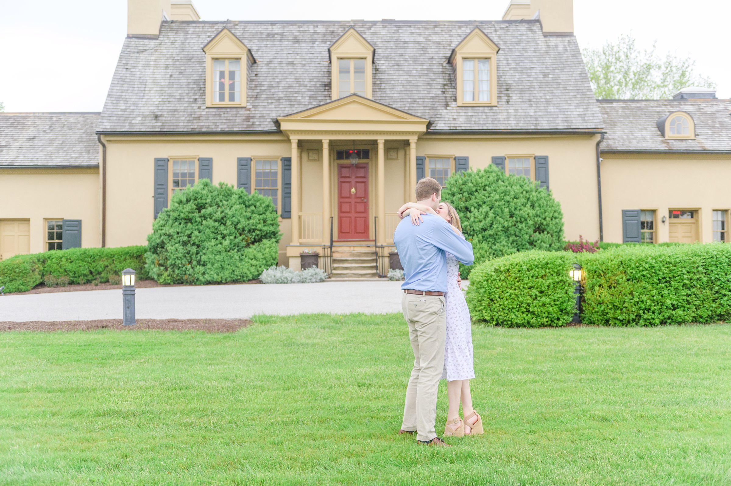 Engaged Couple poses on the lawn at Belmont Manor during a rainy sunset engagement photographed by Baltimore Wedding Photographer Cait Kramer