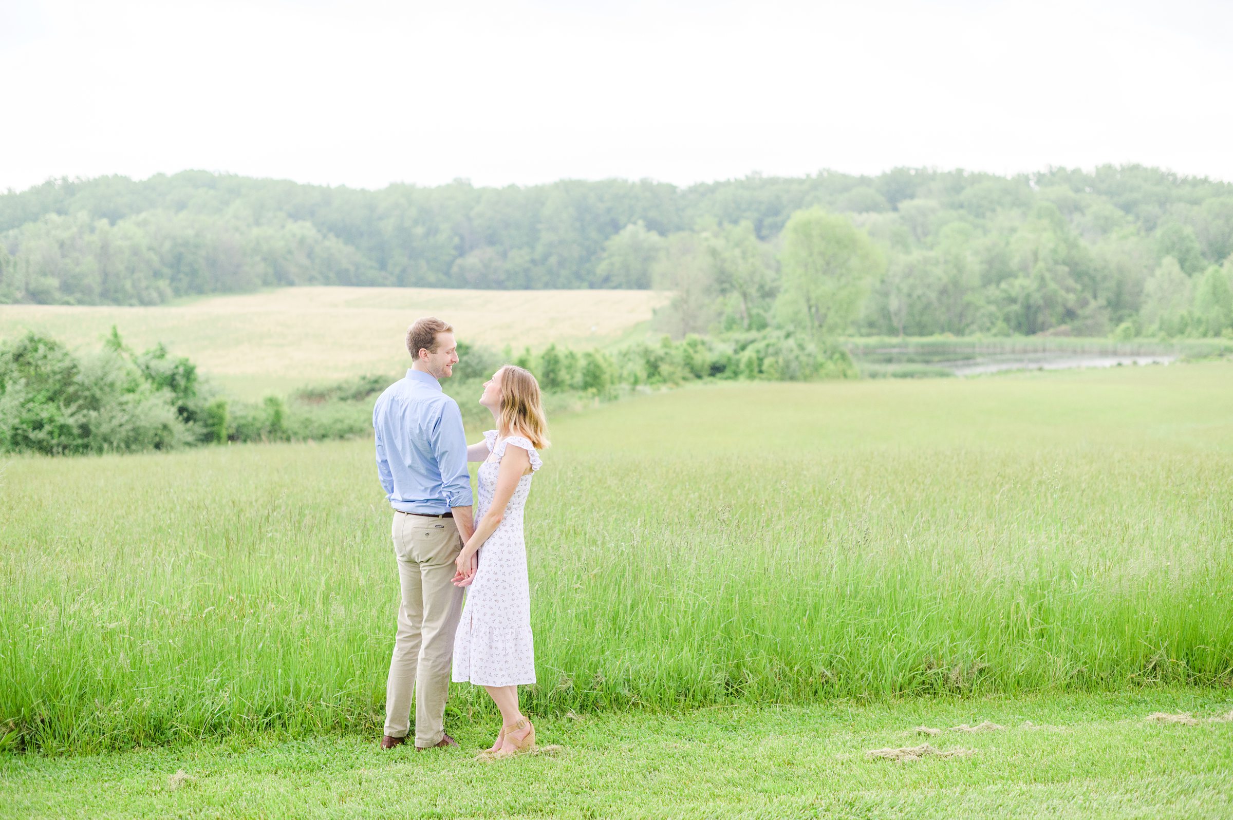 Engaged Couple poses in the fields near Belmont Manor during a rainy sunset engagement photographed by Baltimore Wedding Photographer Cait Kramer