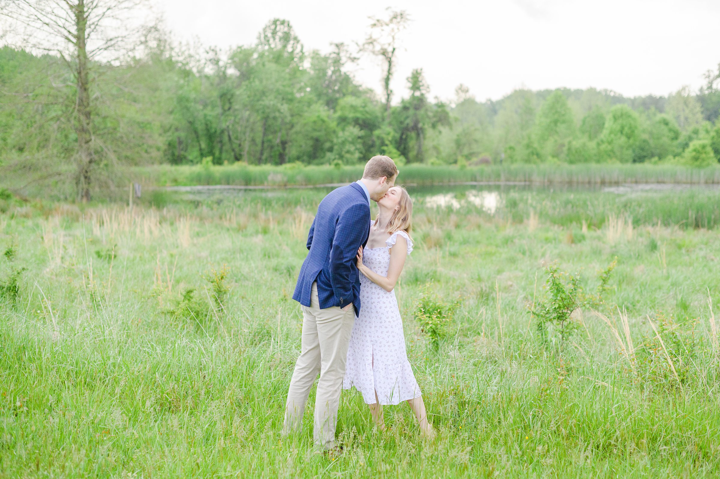 Engaged Couple poses in the fields near Belmont Manor during a rainy sunset engagement photographed by Baltimore Wedding Photographer Cait Kramer