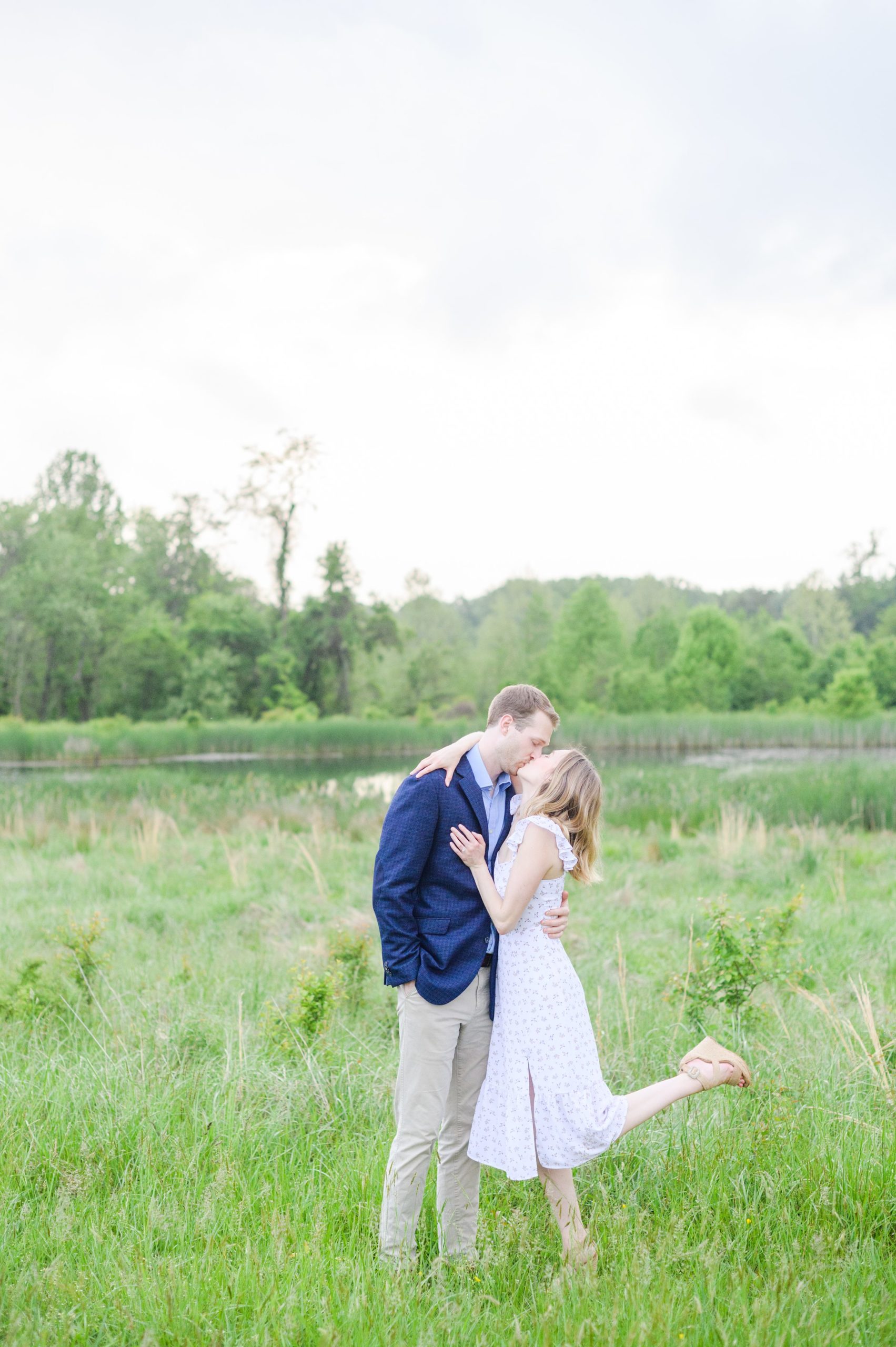 Engaged Couple poses in the fields near Belmont Manor during a rainy sunset engagement photographed by Baltimore Wedding Photographer Cait Kramer