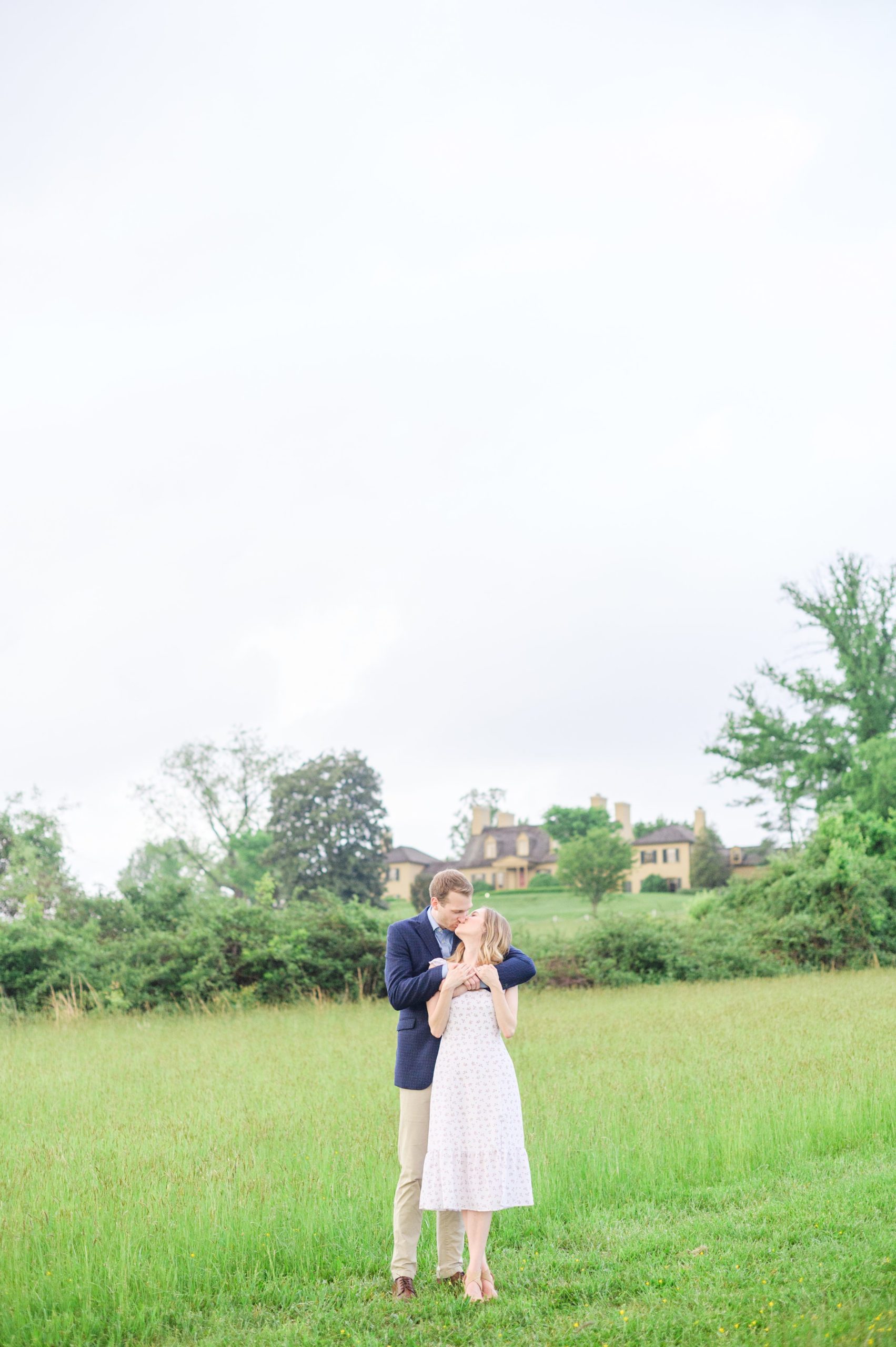 Engaged Couple poses in the fields near Belmont Manor during a rainy sunset engagement photographed by Baltimore Wedding Photographer Cait Kramer