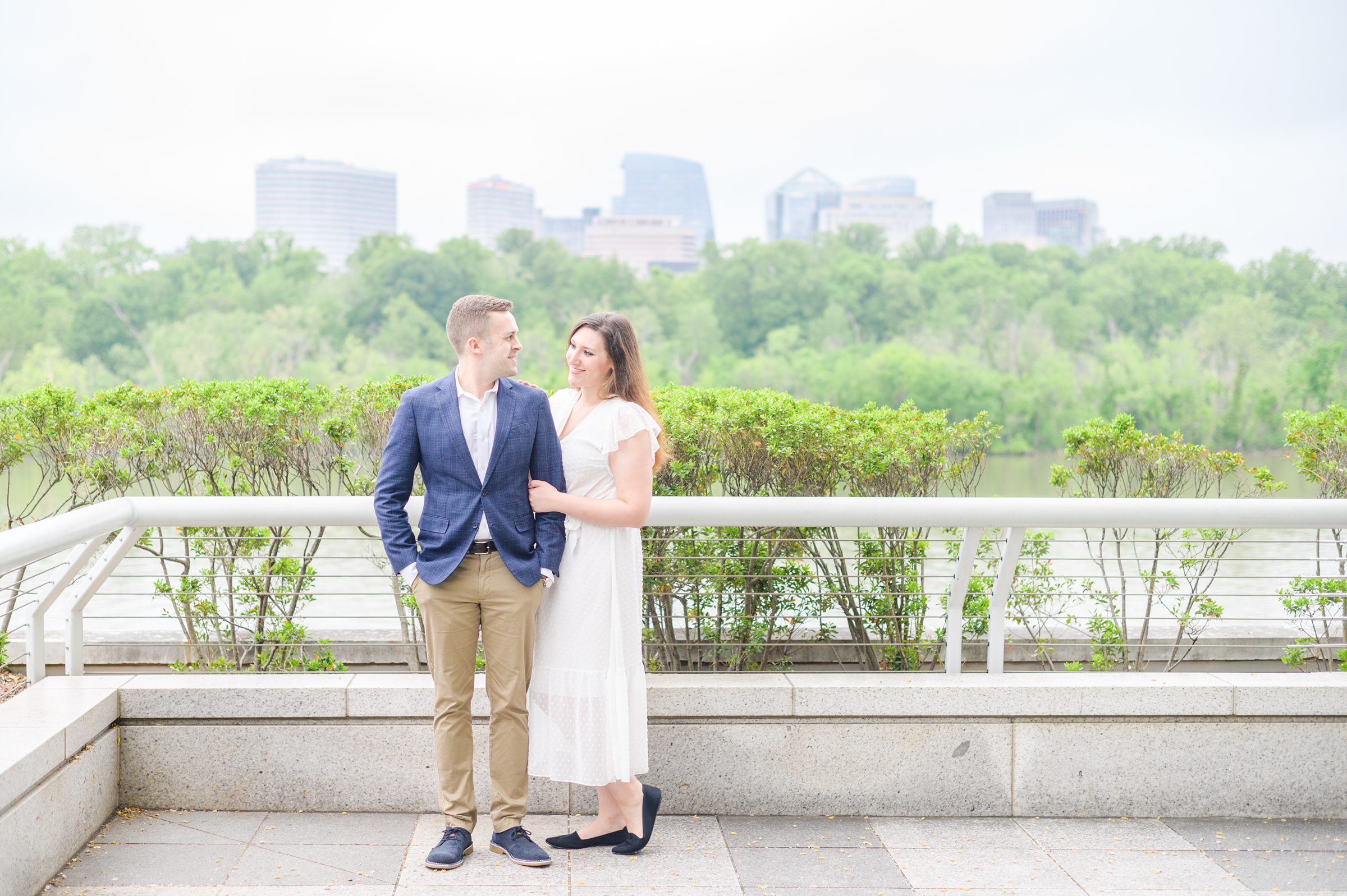 Engaged couple smiles near the Kennedy Center during engagement session at the Kennedy Center photographed by Baltimore Wedding Photographer Cait Kramer Photography