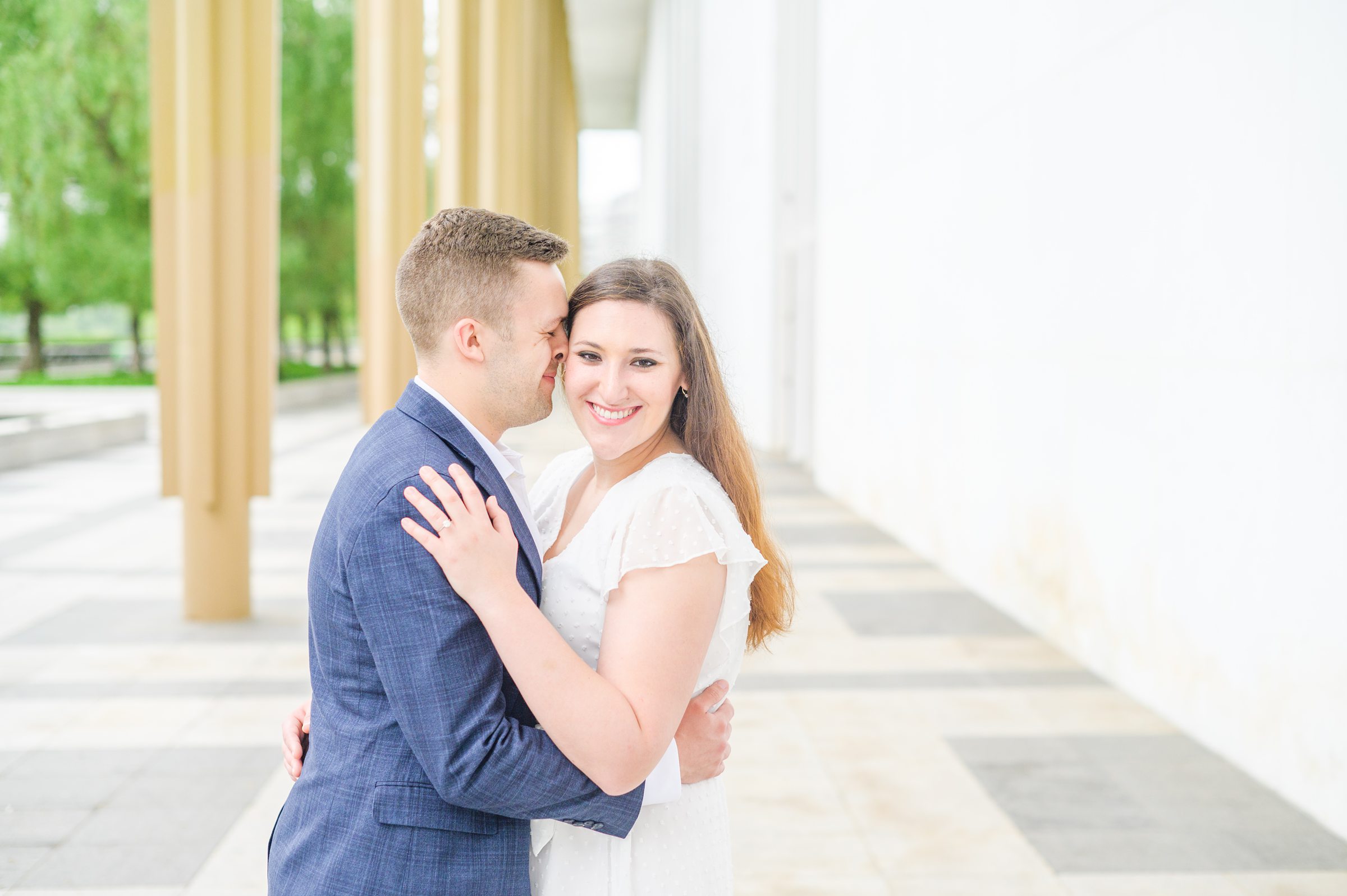 Engaged couple smiles near the Kennedy Center during engagement session at the Kennedy Center photographed by Baltimore Wedding Photographer Cait Kramer Photography