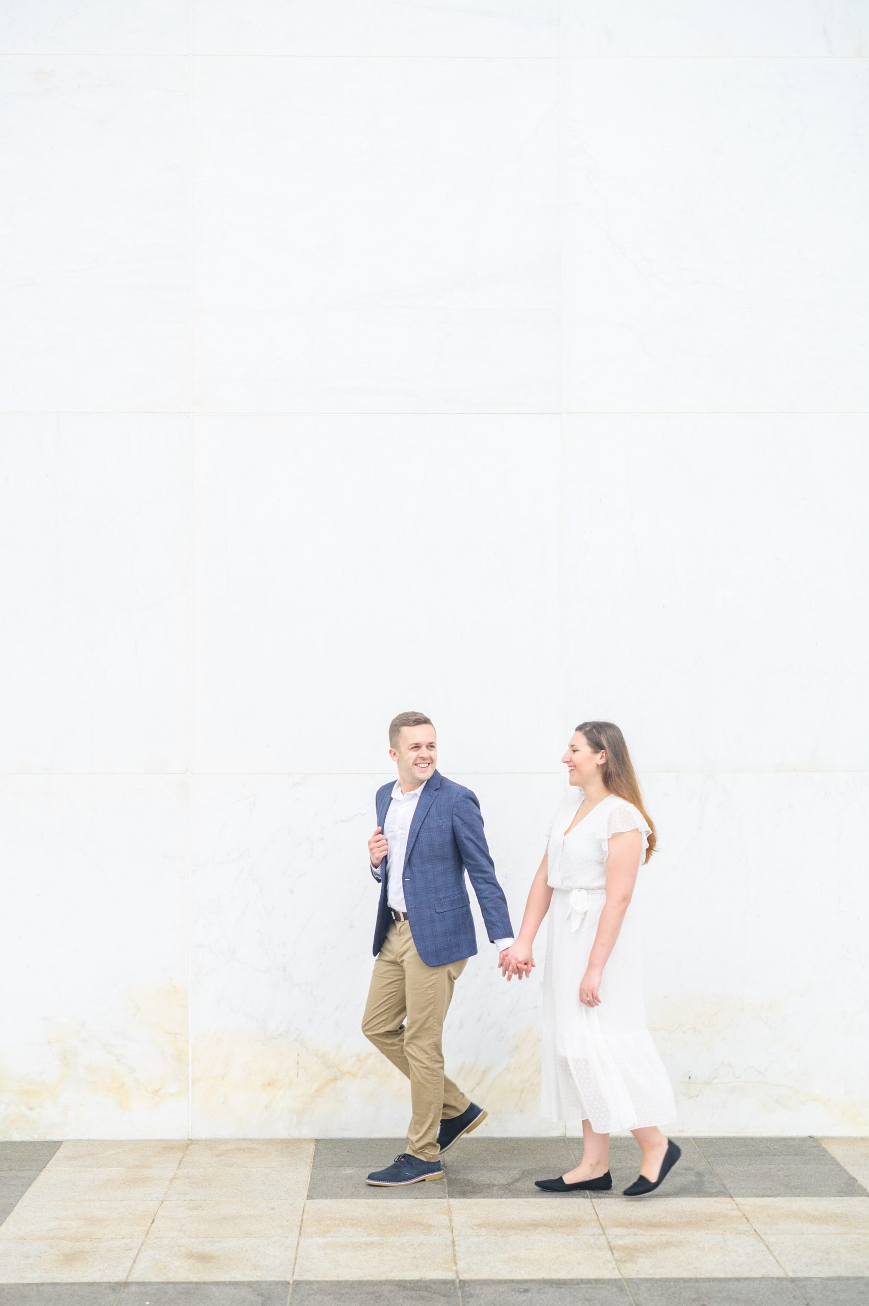 Engaged couple smiles near the Kennedy Center during engagement session at the Kennedy Center photographed by Baltimore Wedding Photographer Cait Kramer Photography