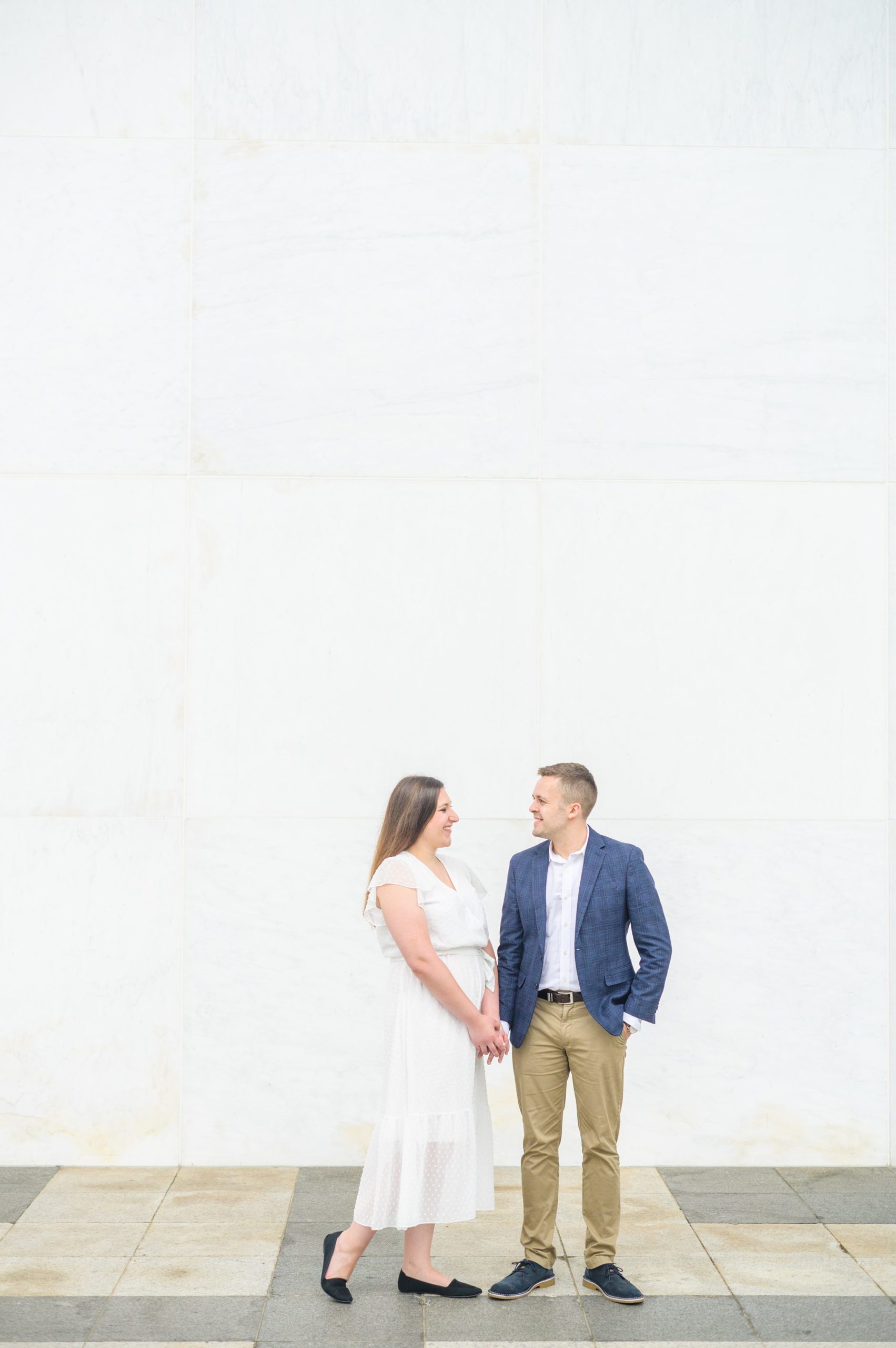 Engaged couple smiles near the Kennedy Center during engagement session at the Kennedy Center photographed by Baltimore Wedding Photographer Cait Kramer Photography