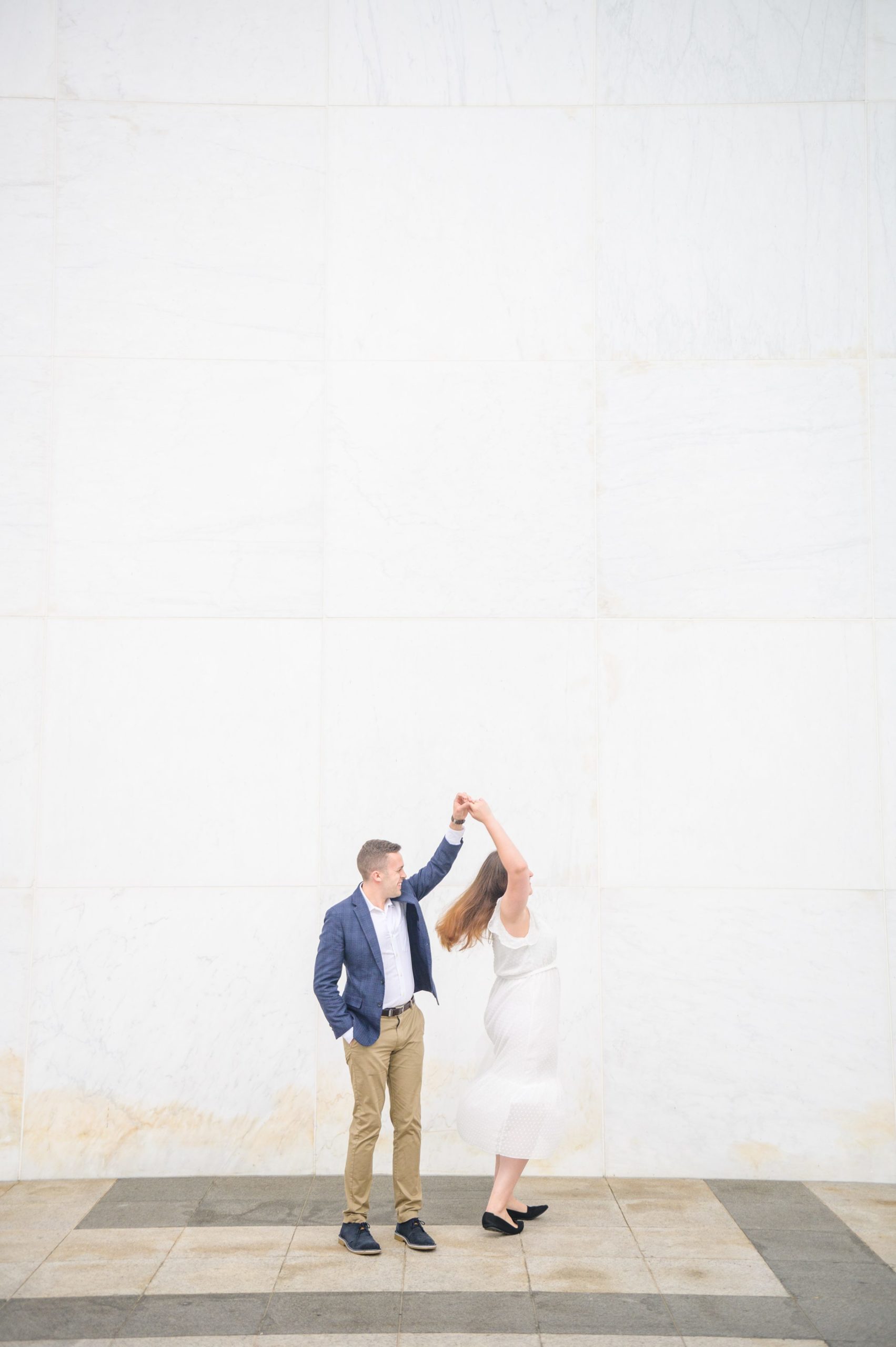 Engaged couple smiles near the Kennedy Center during engagement session at the Kennedy Center photographed by Baltimore Wedding Photographer Cait Kramer Photography