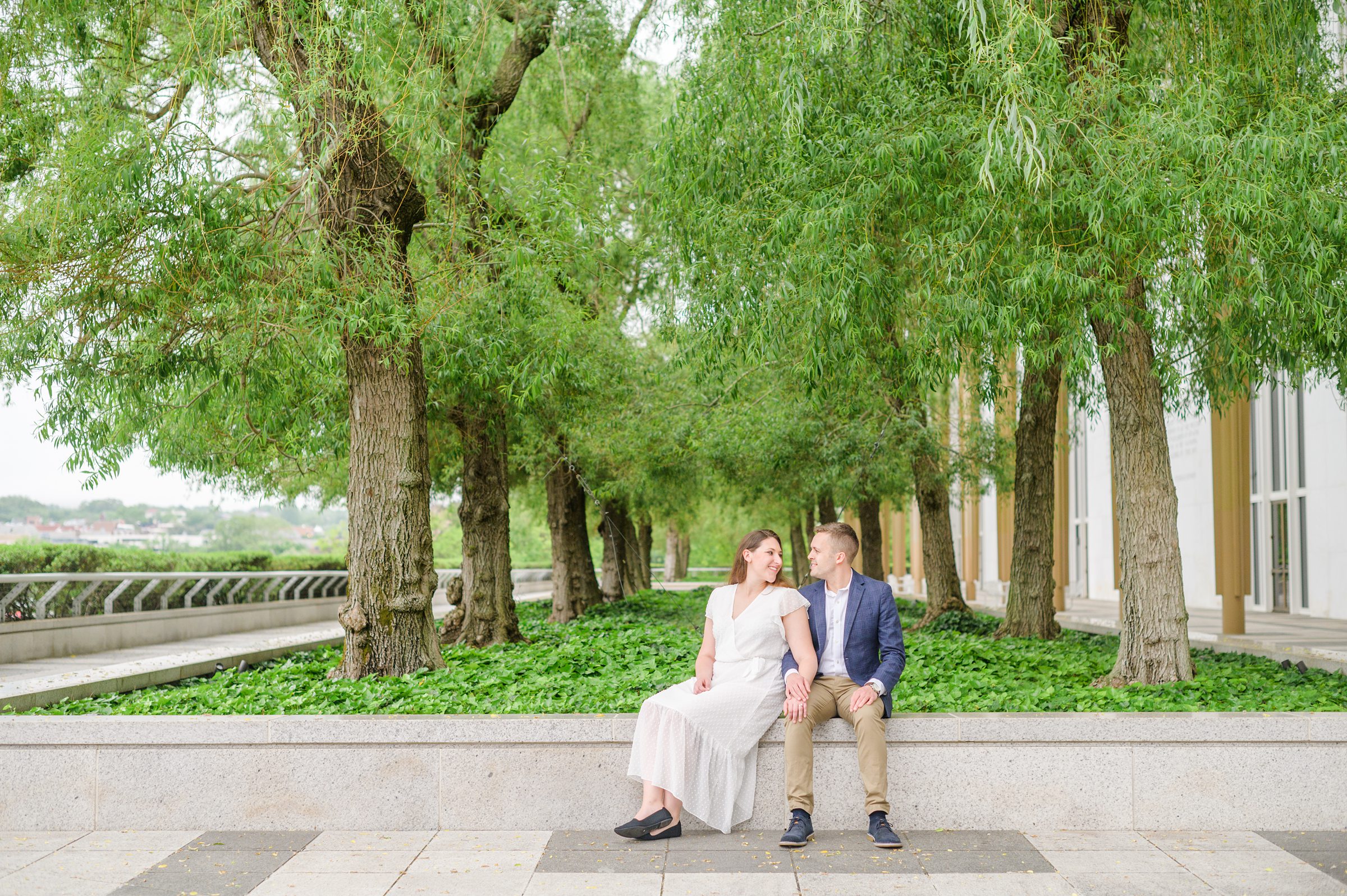 Engaged couple smiles near the Kennedy Center during engagement session at the Kennedy Center photographed by Baltimore Wedding Photographer Cait Kramer Photography