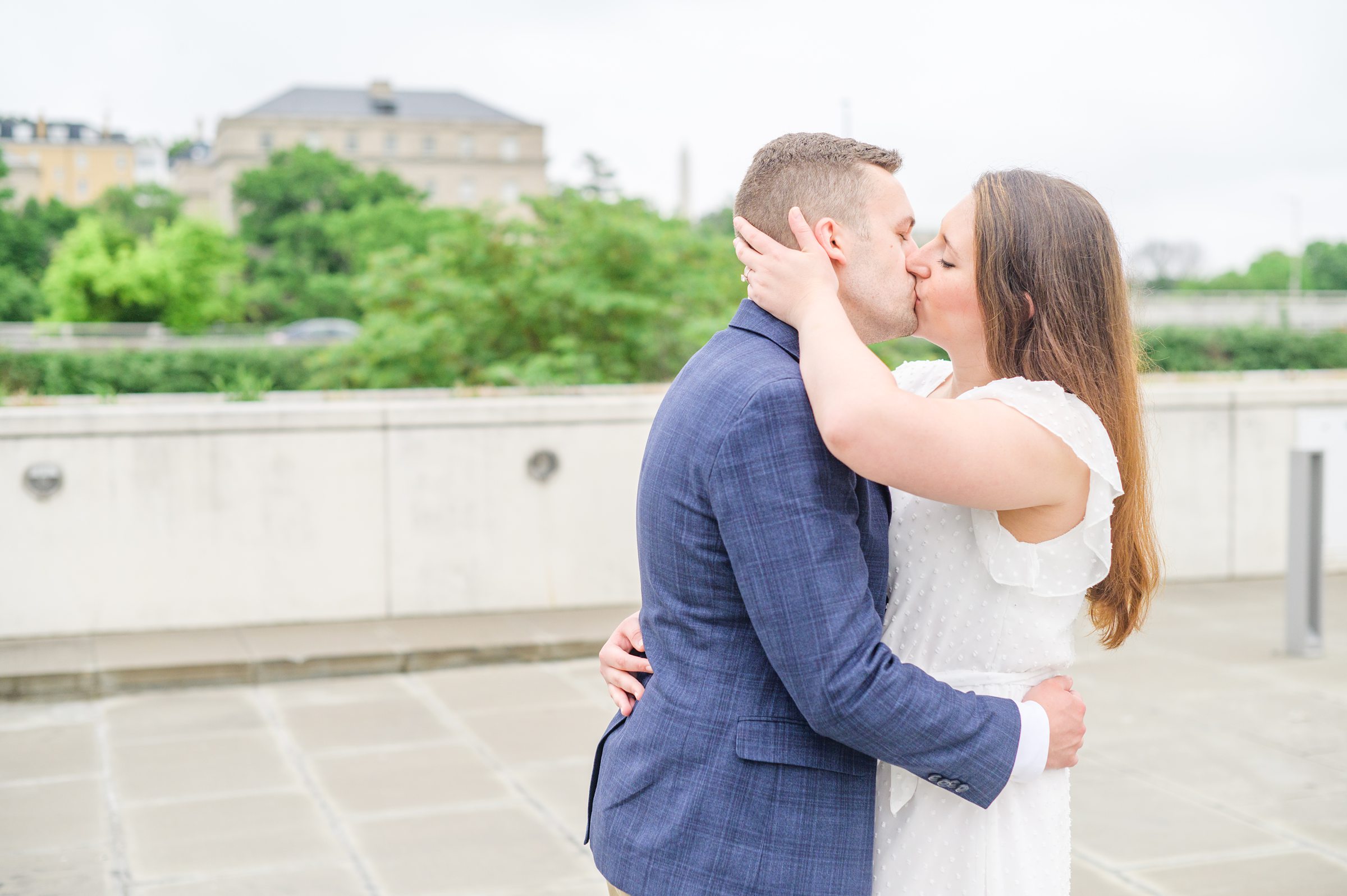 Engaged couple smiles near the Kennedy Center during engagement session at the Kennedy Center photographed by Baltimore Wedding Photographer Cait Kramer Photography