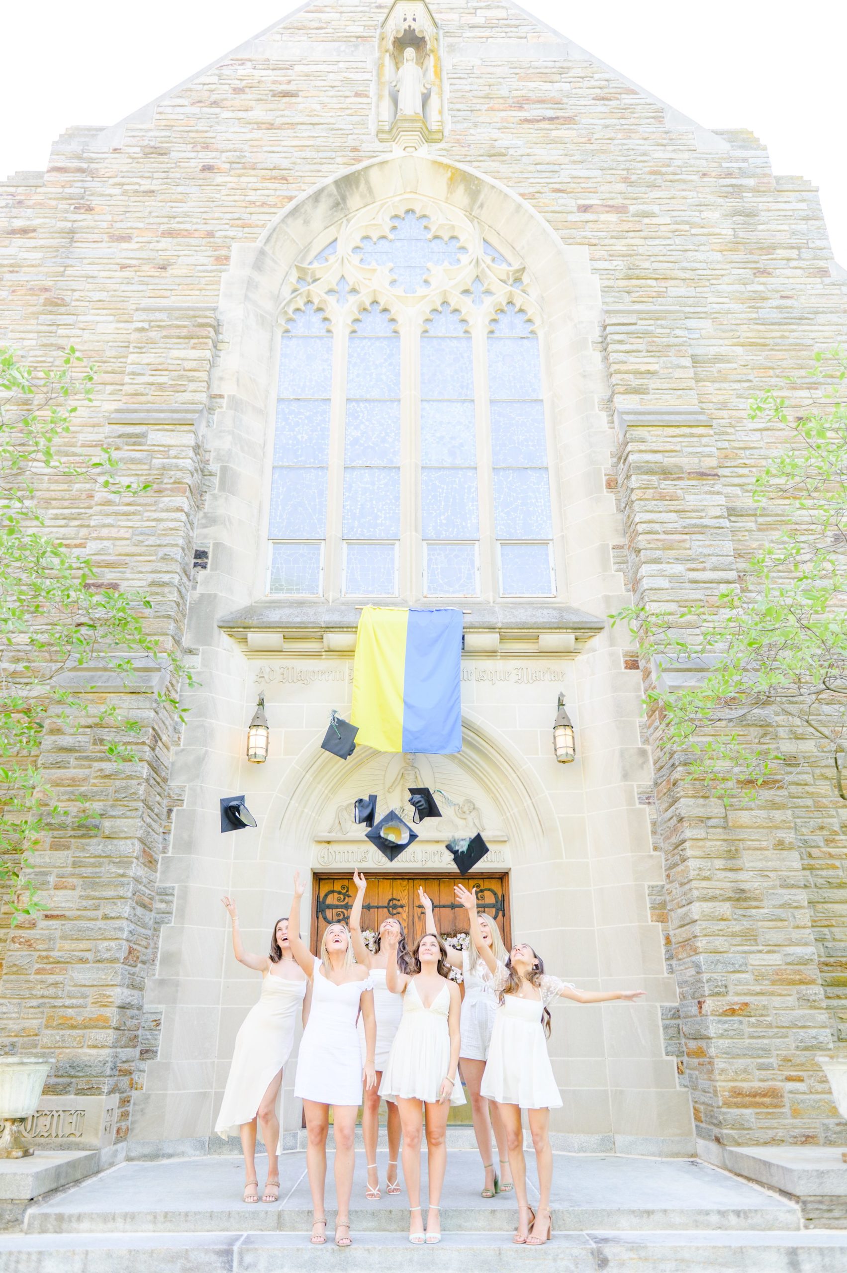 Loyola seniors pose on Loyola University Maryland's campus in graduation attire during Baltimore Grad Session photographed by Cait Kramer