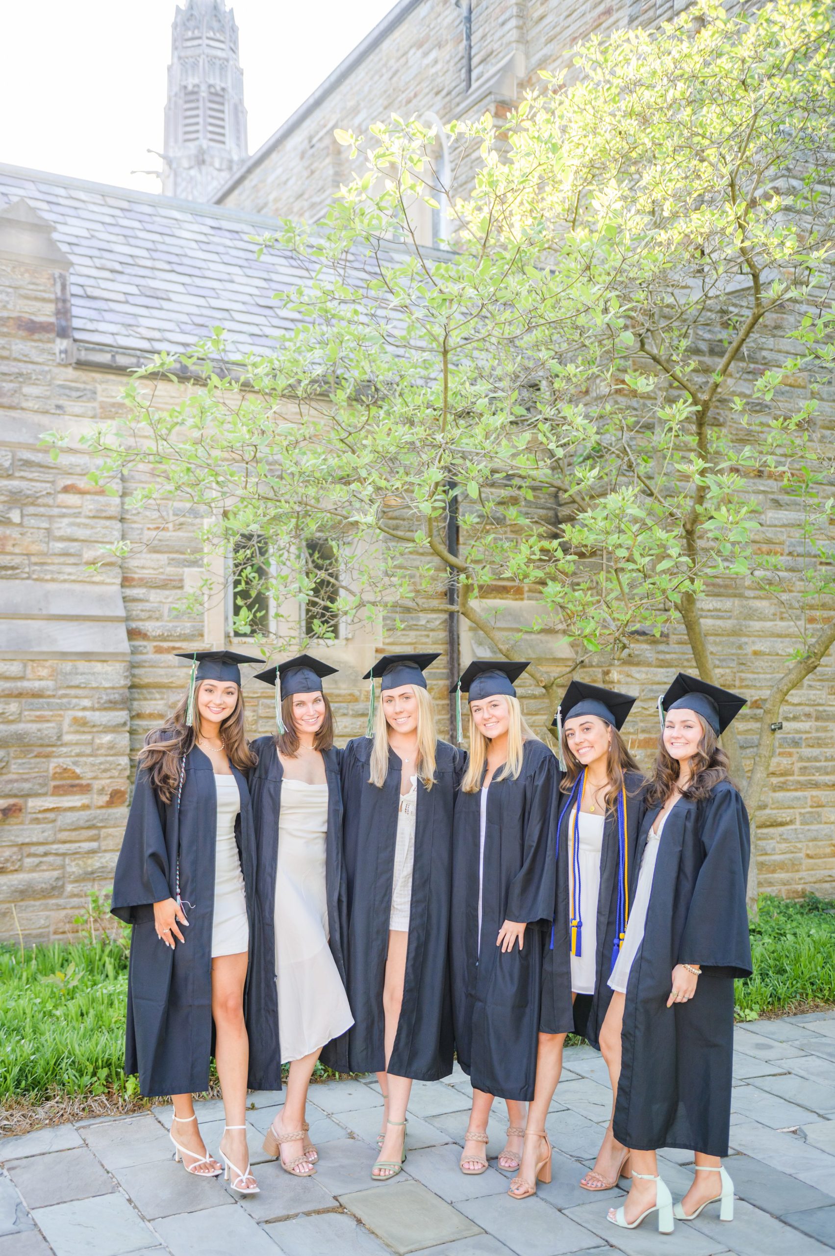 Loyola seniors pose on Loyola University Maryland's campus in graduation attire during Baltimore Grad Session photographed by Cait Kramer