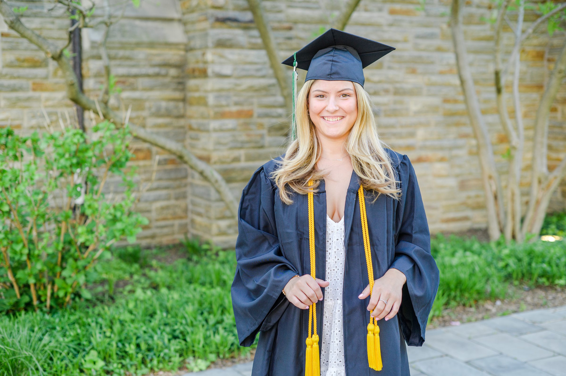 Loyola seniors pose on Loyola University Maryland's campus in graduation attire during Baltimore Grad Session photographed by Cait Kramer