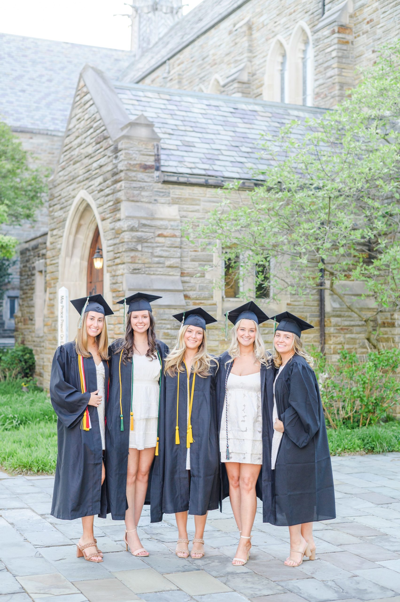 Loyola seniors pose on Loyola University Maryland's campus in graduation attire during Baltimore Grad Session photographed by Cait Kramer