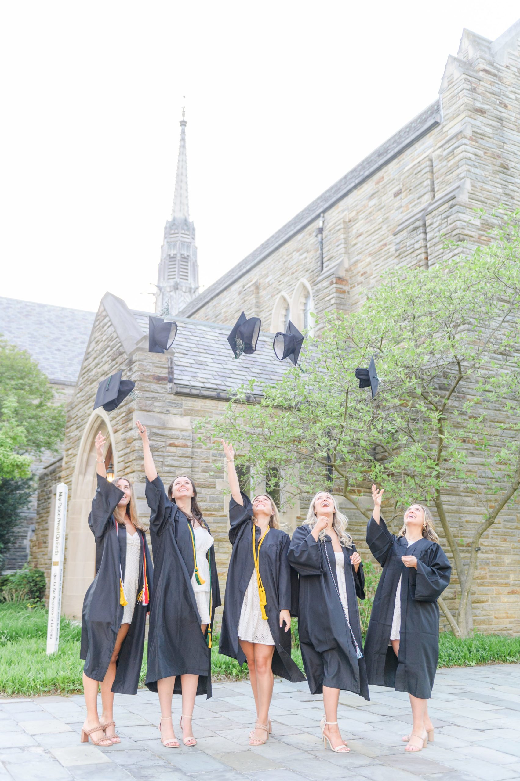 Loyola seniors pose on Loyola University Maryland's campus in graduation attire during Baltimore Grad Session photographed by Cait Kramer