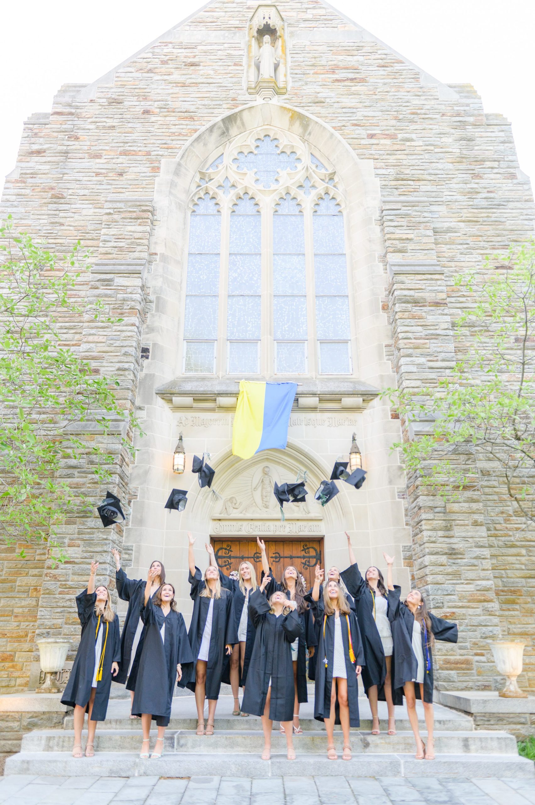 Loyola seniors pose on Loyola University Maryland's campus in graduation attire during Baltimore Grad Session photographed by Cait Kramer