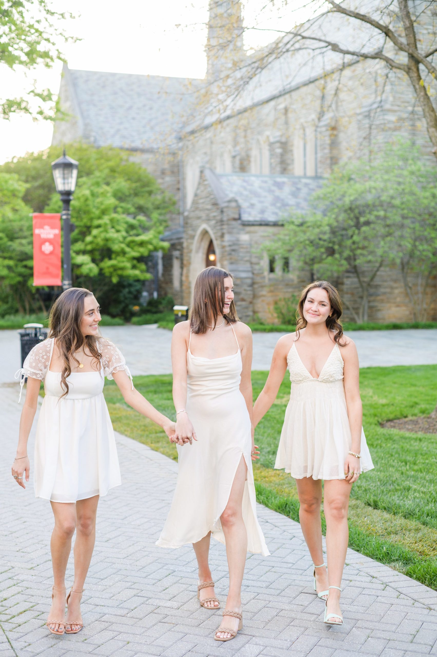 Loyola seniors pose on Loyola University Maryland's campus in graduation attire during Baltimore Grad Session photographed by Cait Kramer