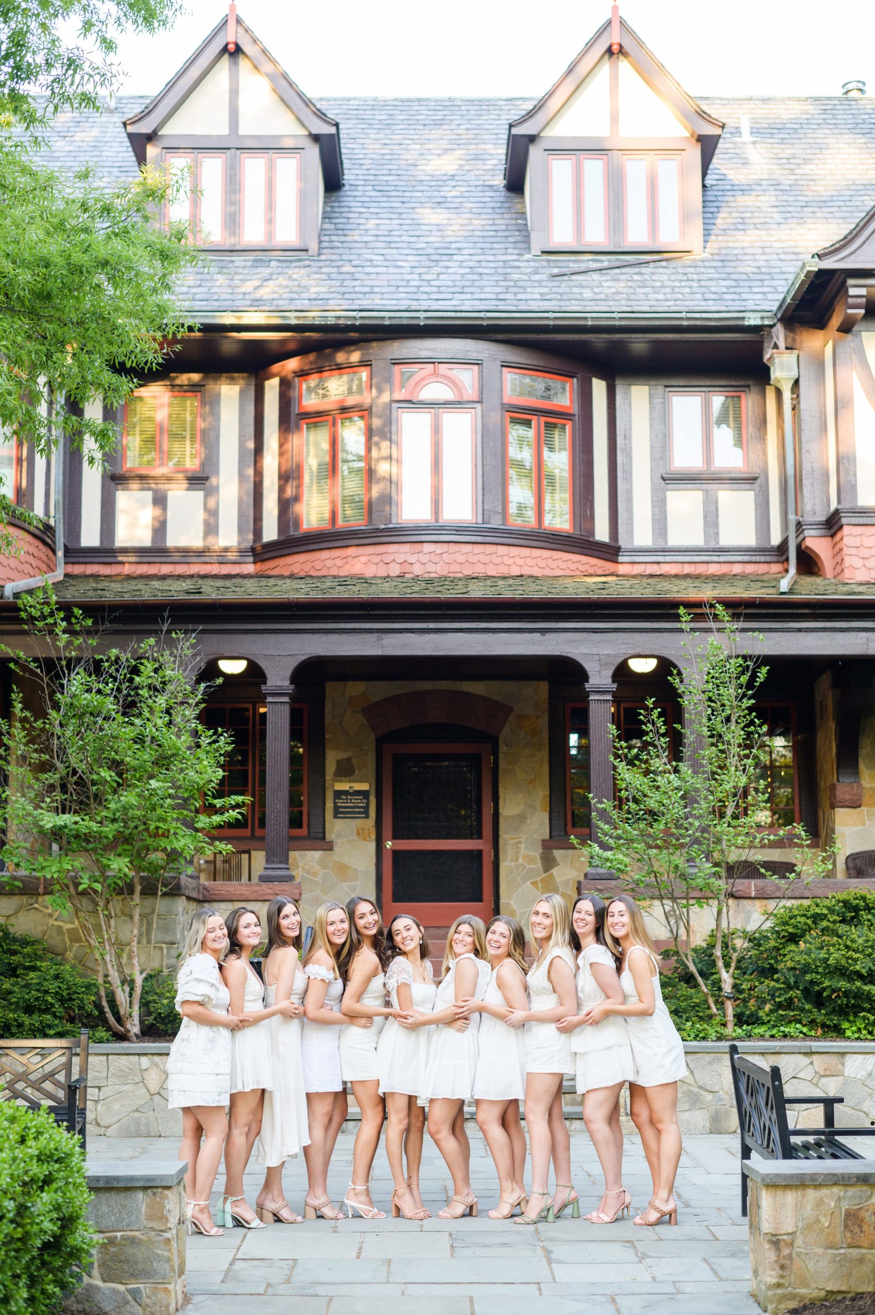 Loyola seniors pose on Loyola University Maryland's campus in graduation attire during Baltimore Grad Session photographed by Cait Kramer