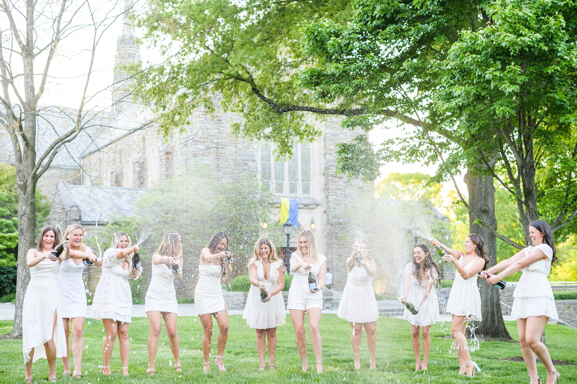 Loyola seniors pose on Loyola University Maryland's campus in graduation attire during Baltimore Grad Session photographed by Cait Kramer