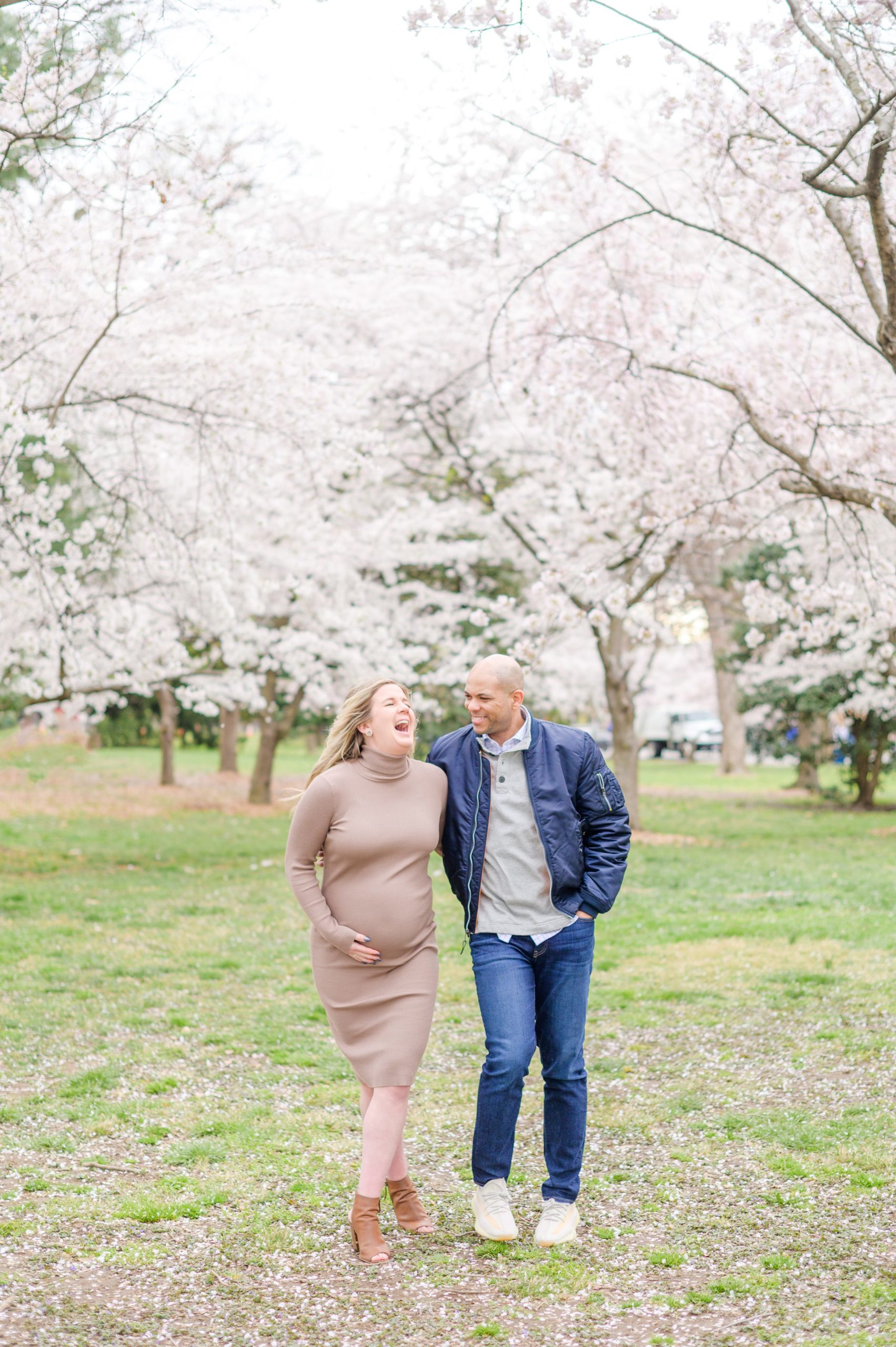 Mama and dad-to-be poses with her bump amongst the cherry blossoms at the Washington, DC Tidal Basin during a maternity session photographed by Cait Kramer Photography