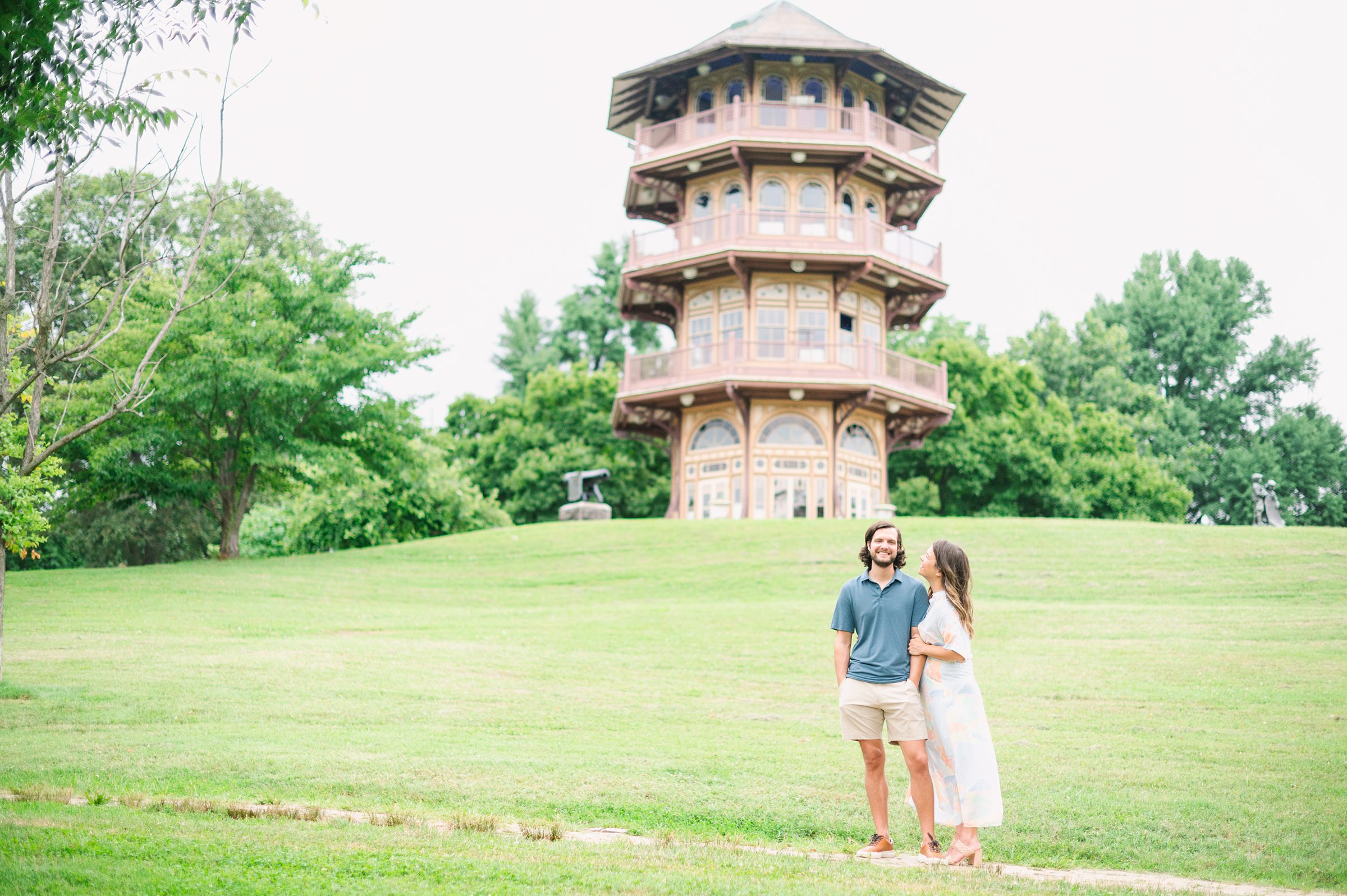 Expecting couple smiles during Patterson Park maternity session photographed by Baltimore Photographer Cait Kramer.