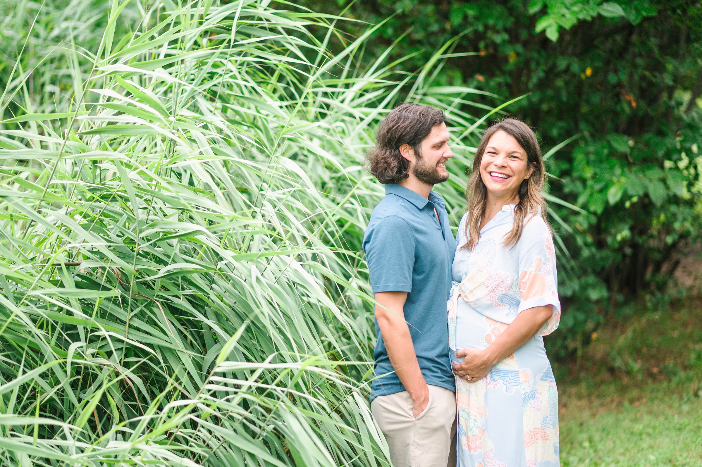 Expecting couple smiles during Patterson Park maternity session photographed by Baltimore Photographer Cait Kramer.