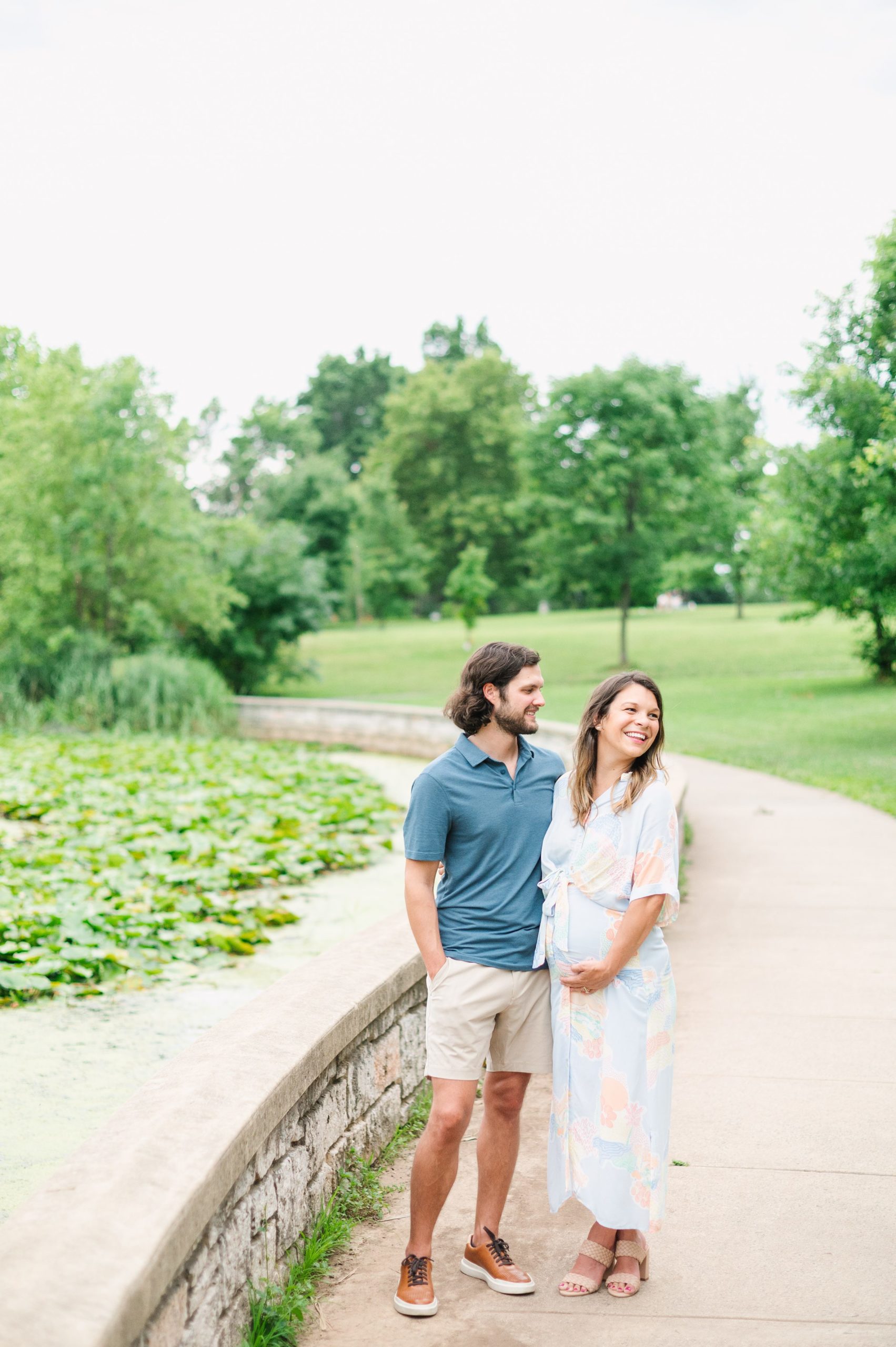 Expecting couple smiles during Patterson Park maternity session photographed by Baltimore Photographer Cait Kramer.