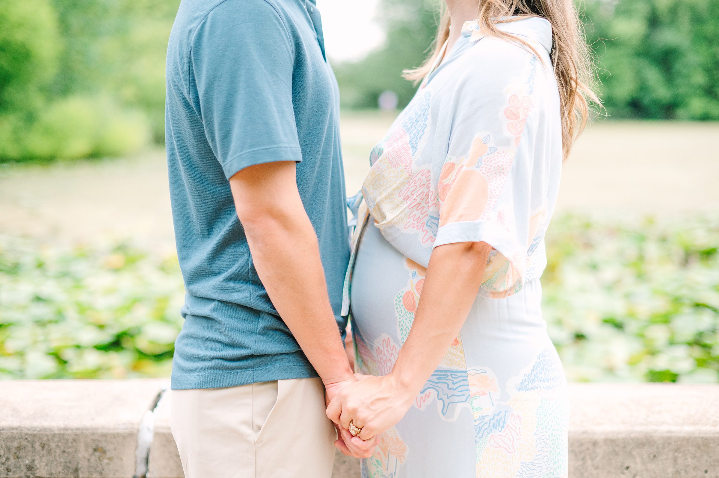 Expecting couple smiles during Patterson Park maternity session photographed by Baltimore Photographer Cait Kramer.