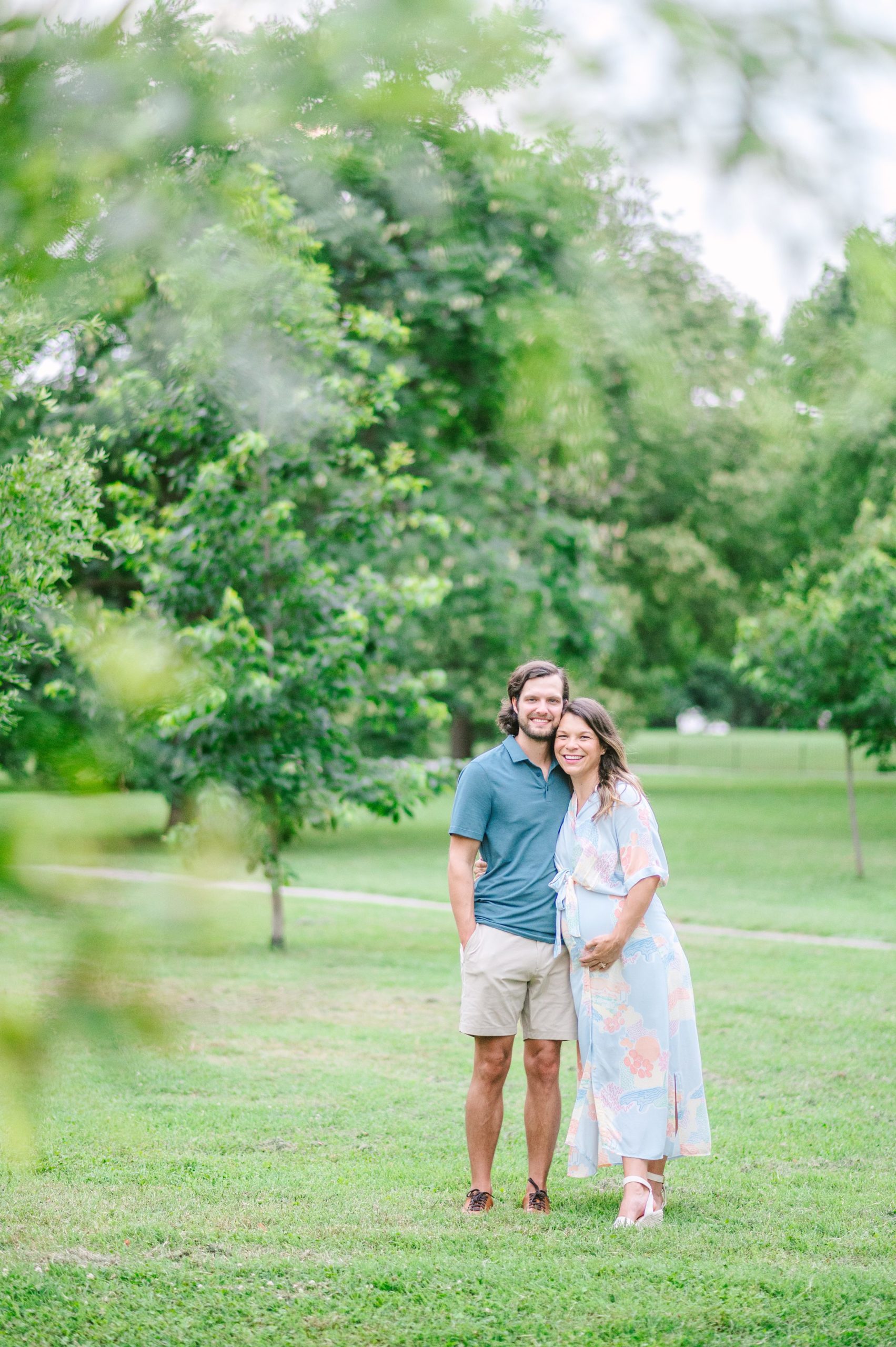 Expecting couple smiles during Patterson Park maternity session photographed by Baltimore Photographer Cait Kramer.