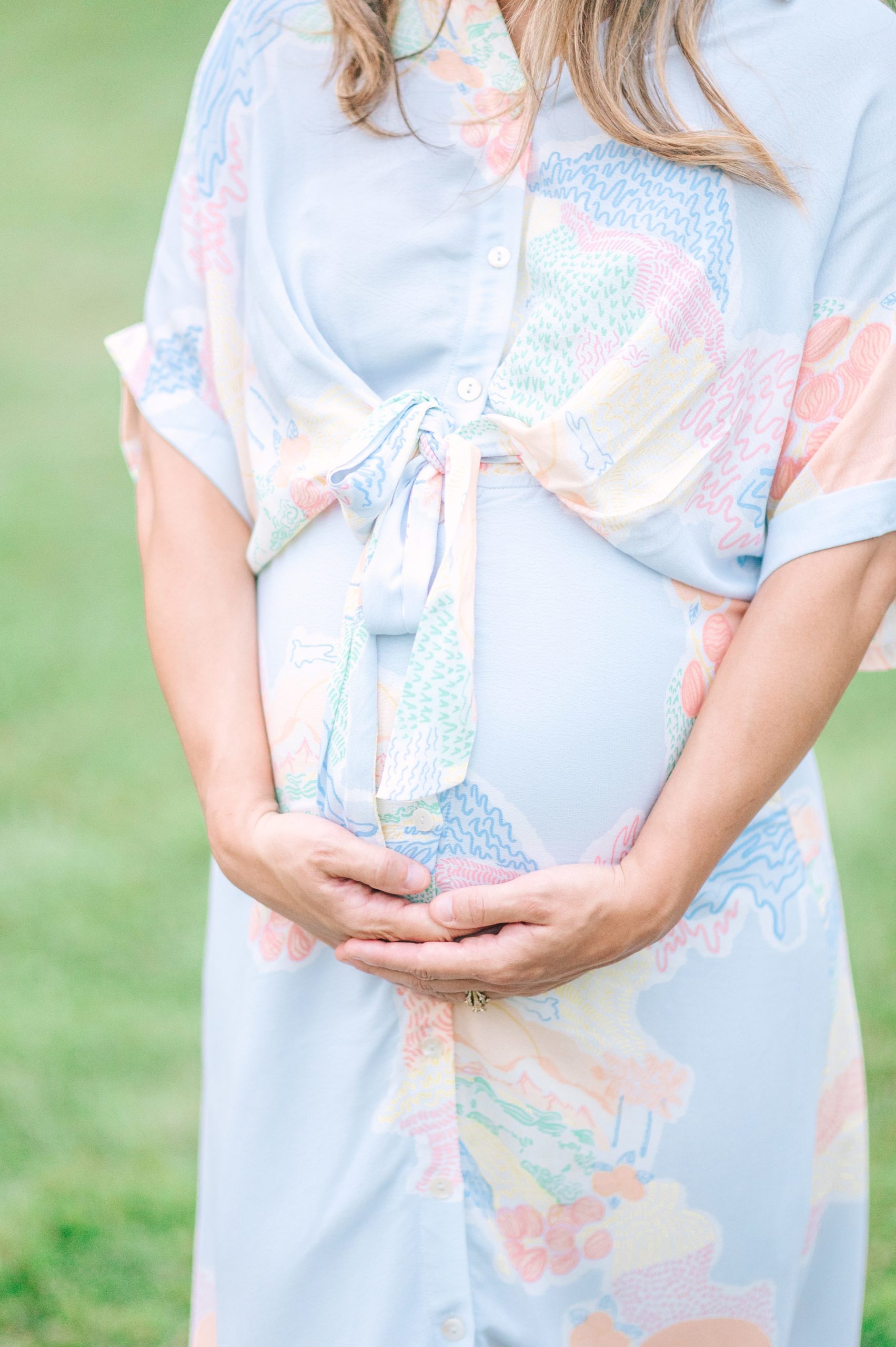 Expecting couple smiles during Patterson Park maternity session photographed by Baltimore Photographer Cait Kramer.