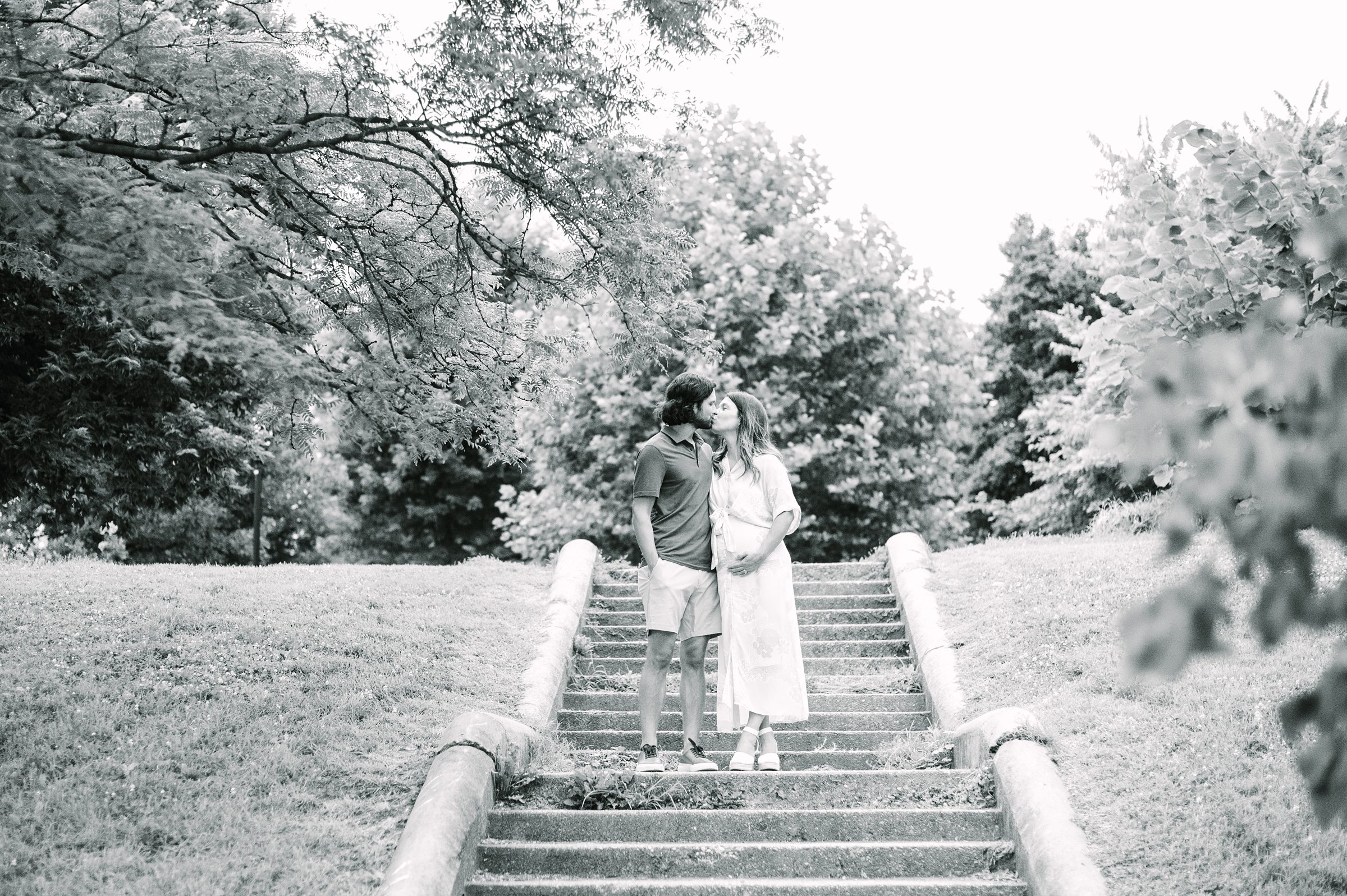 Expecting couple smiles during Patterson Park maternity session photographed by Baltimore Photographer Cait Kramer.