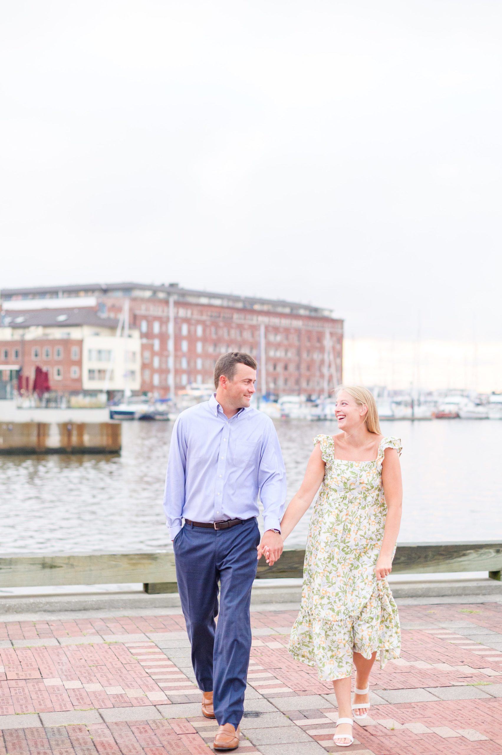 Couple poses on Broadway pier during Fells Point engagement session photographed by Baltimore wedding photographer Cait Kramer