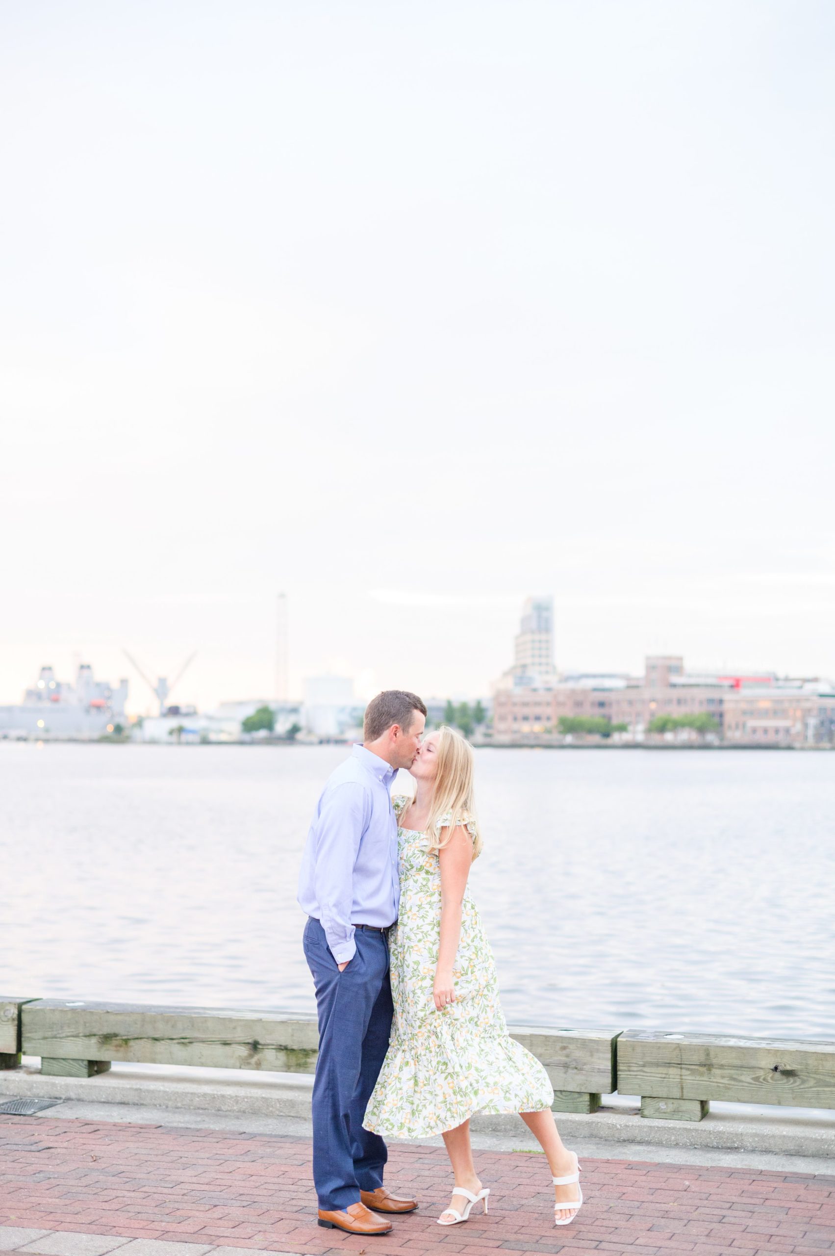 Couple poses on Broadway pier during Fells Point engagement session photographed by Baltimore wedding photographer Cait Kramer