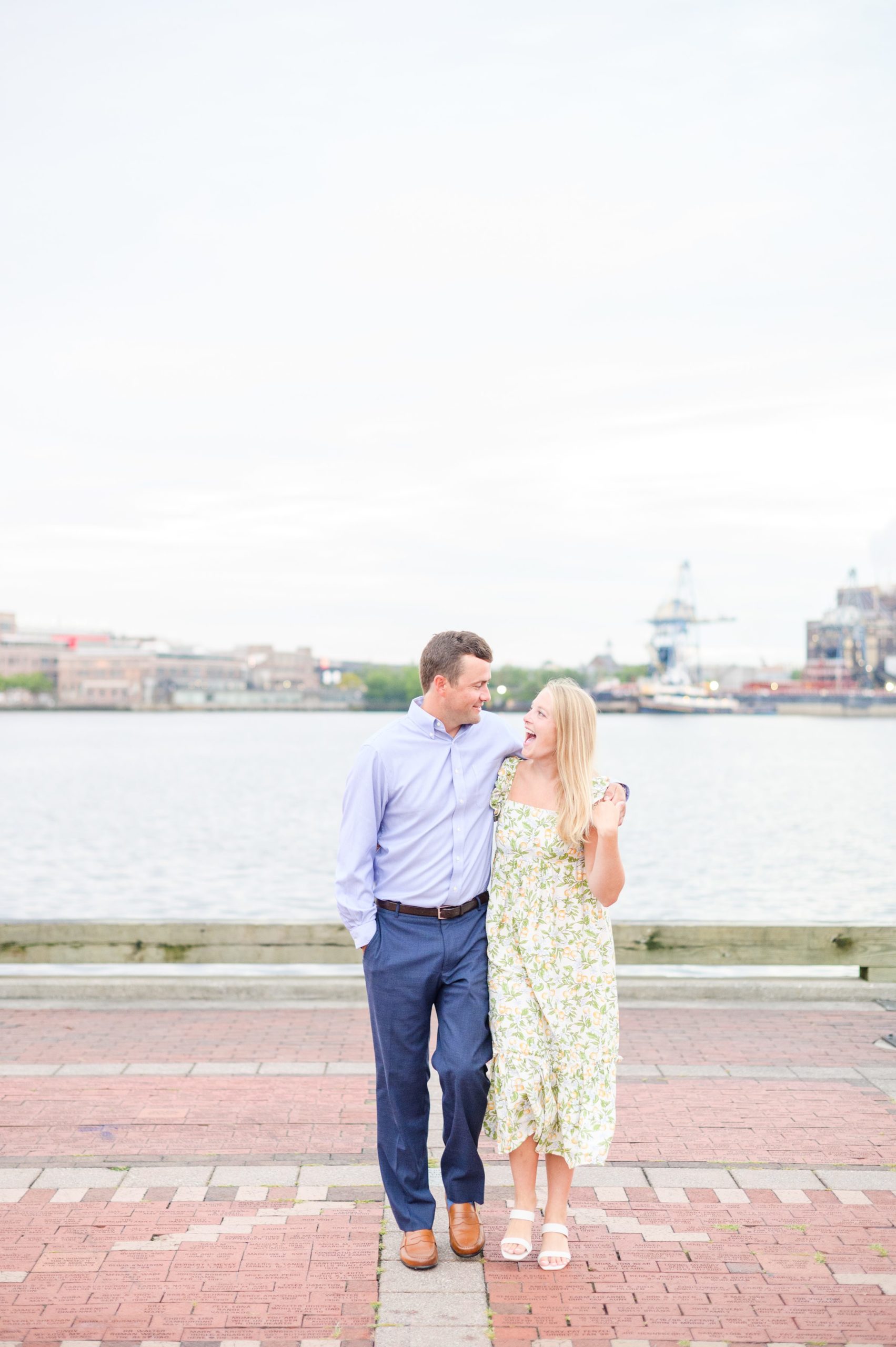 Couple poses on Broadway pier during Fells Point engagement session photographed by Baltimore wedding photographer Cait Kramer