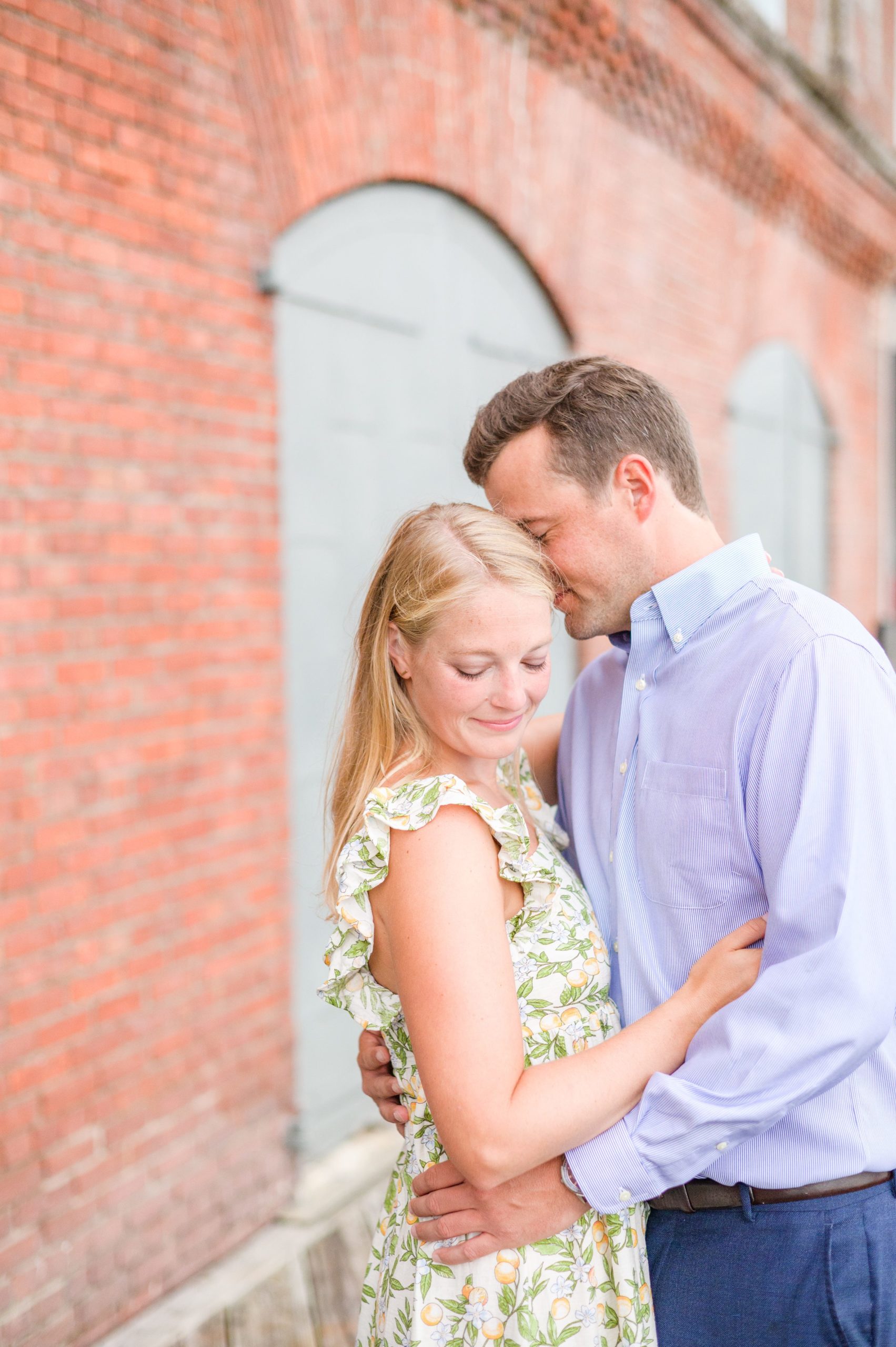 Couple poses near Henderson's Wharf during Fells Point engagement session photographed by Baltimore wedding photographer Cait Kramer