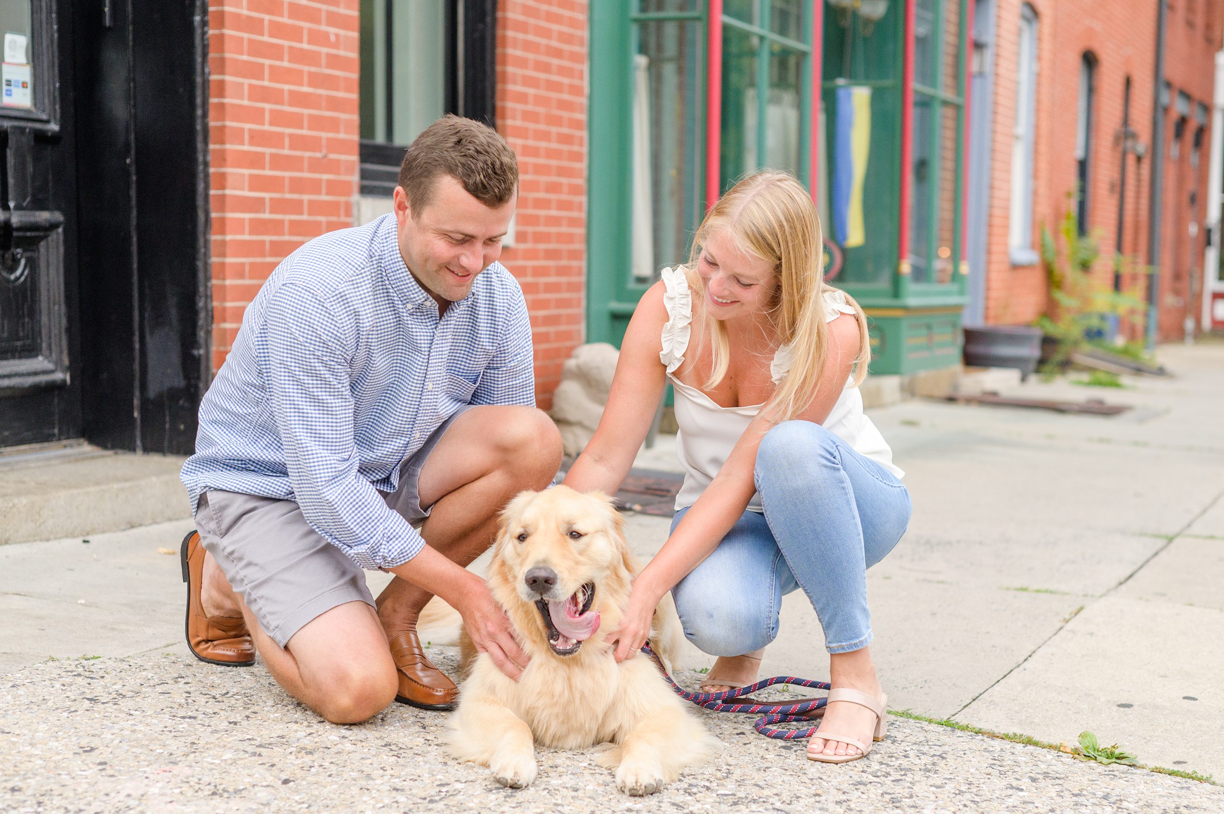 Couple poses in their neighborhood with their dog during Fells Point engagement session photographed by Baltimore wedding photographer Cait Kramer