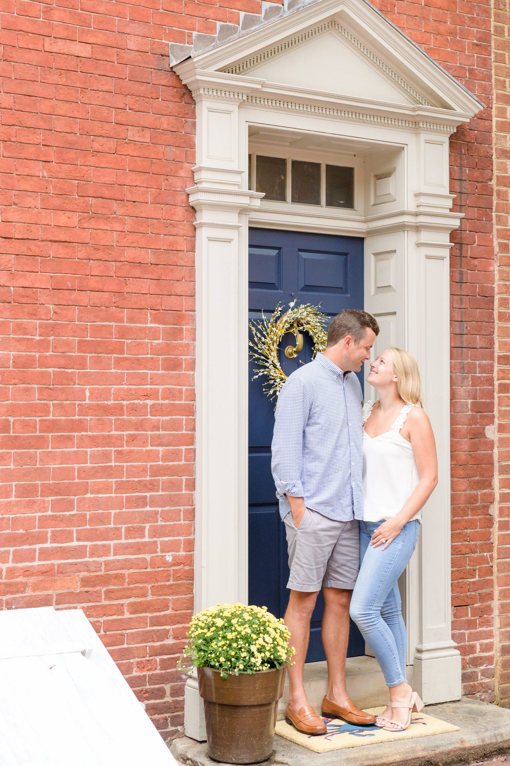 Couple poses in their neighborhood during Fells Point engagement session photographed by Baltimore wedding photographer Cait Kramer