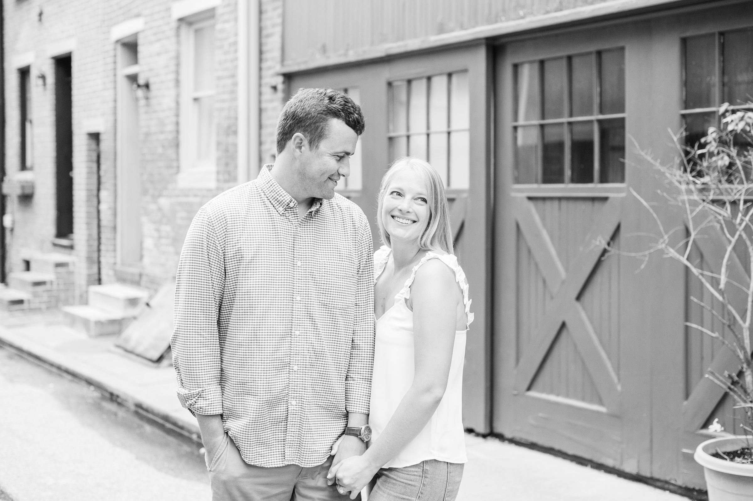 Couple poses in their neighborhood during Fells Point engagement session photographed by Baltimore wedding photographer Cait Kramer