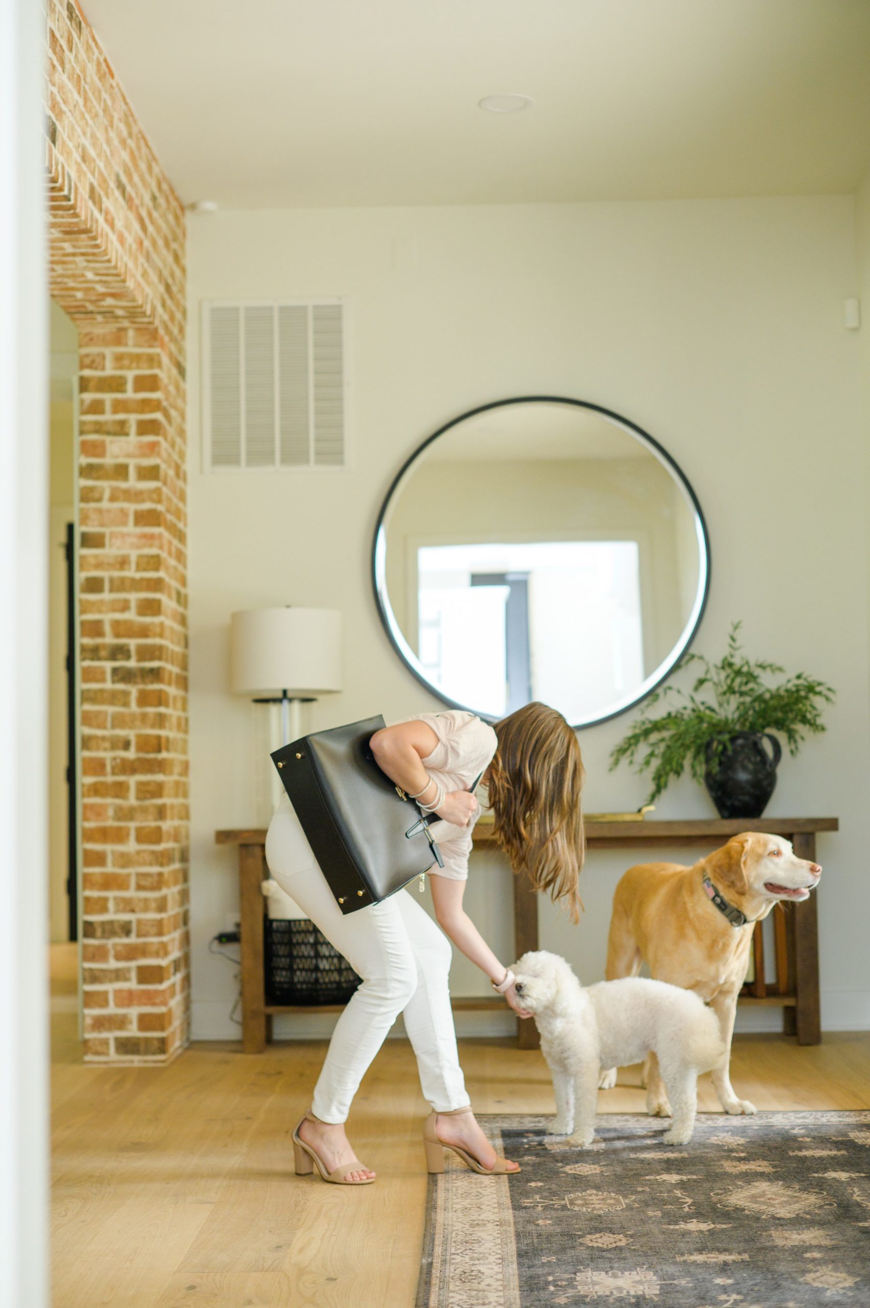 Stacey Caito, Chantilly Realtor, pets her dogs on the way out the door during her brand session photographed by Virginia brand photographer, Cait Kramer Photography