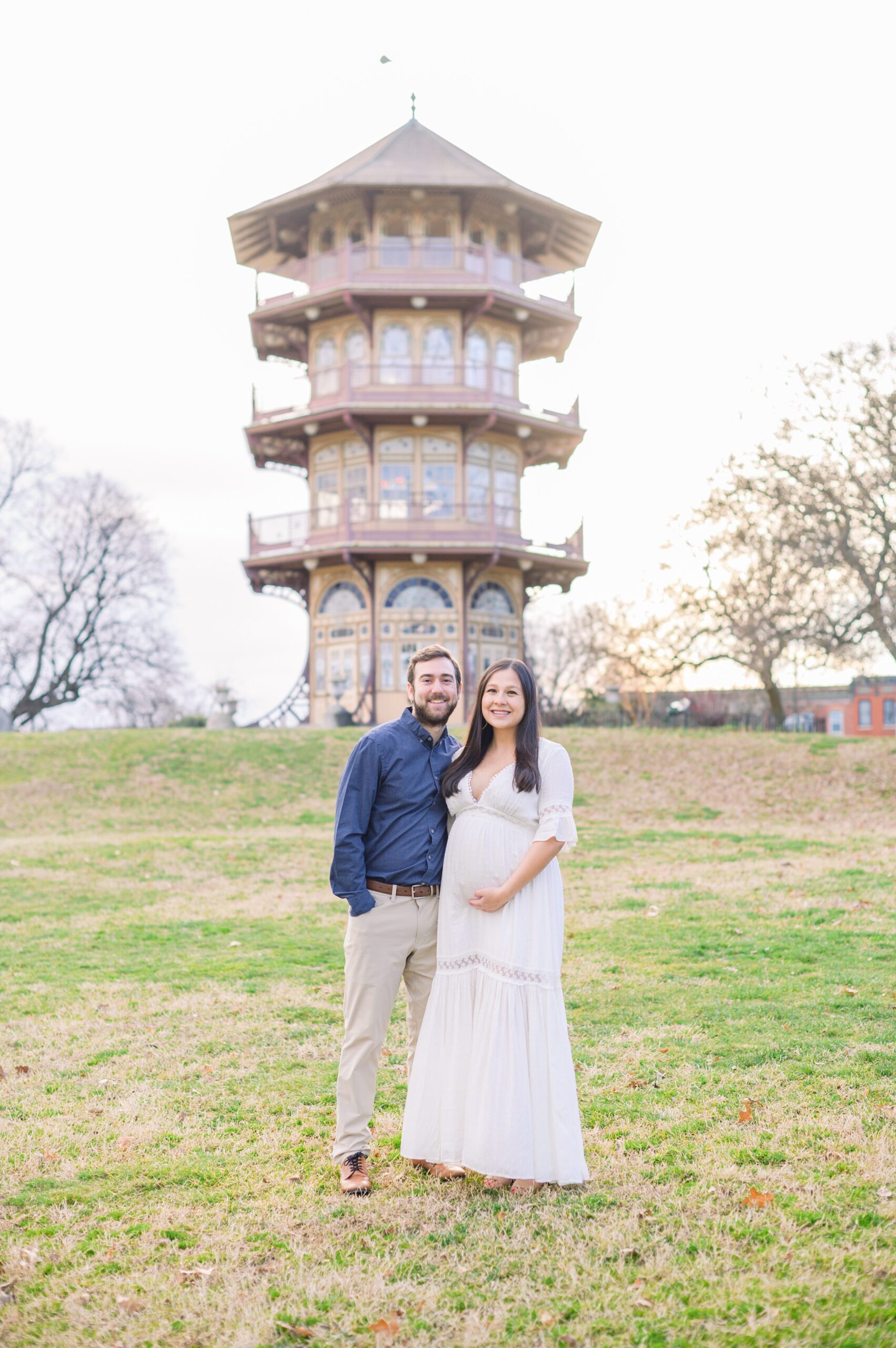 Abby and Nick's maternity photos in Patterson Park in Baltimore County featuring a stunning golden hour and beautiful pink trees.