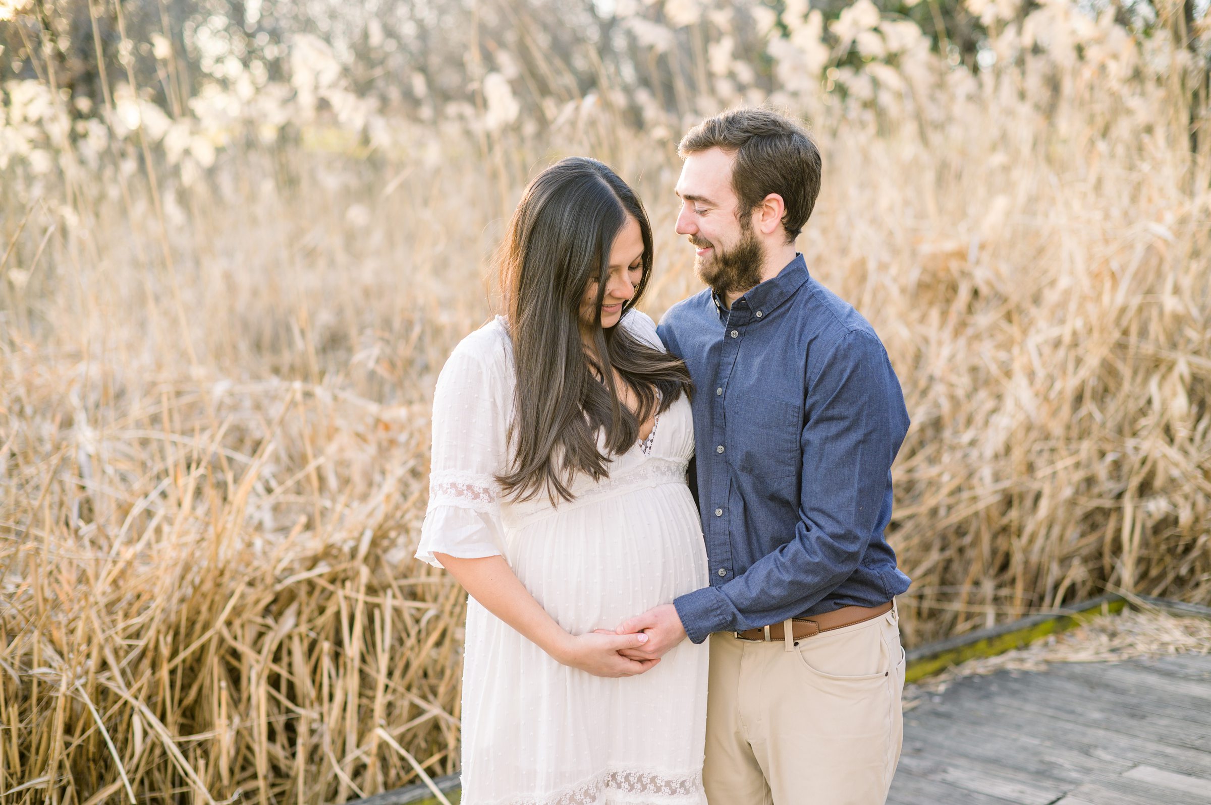 Abby and Nick's maternity session in Patterson Park in Baltimore County featuring a stunning golden hour and beautiful pink trees.