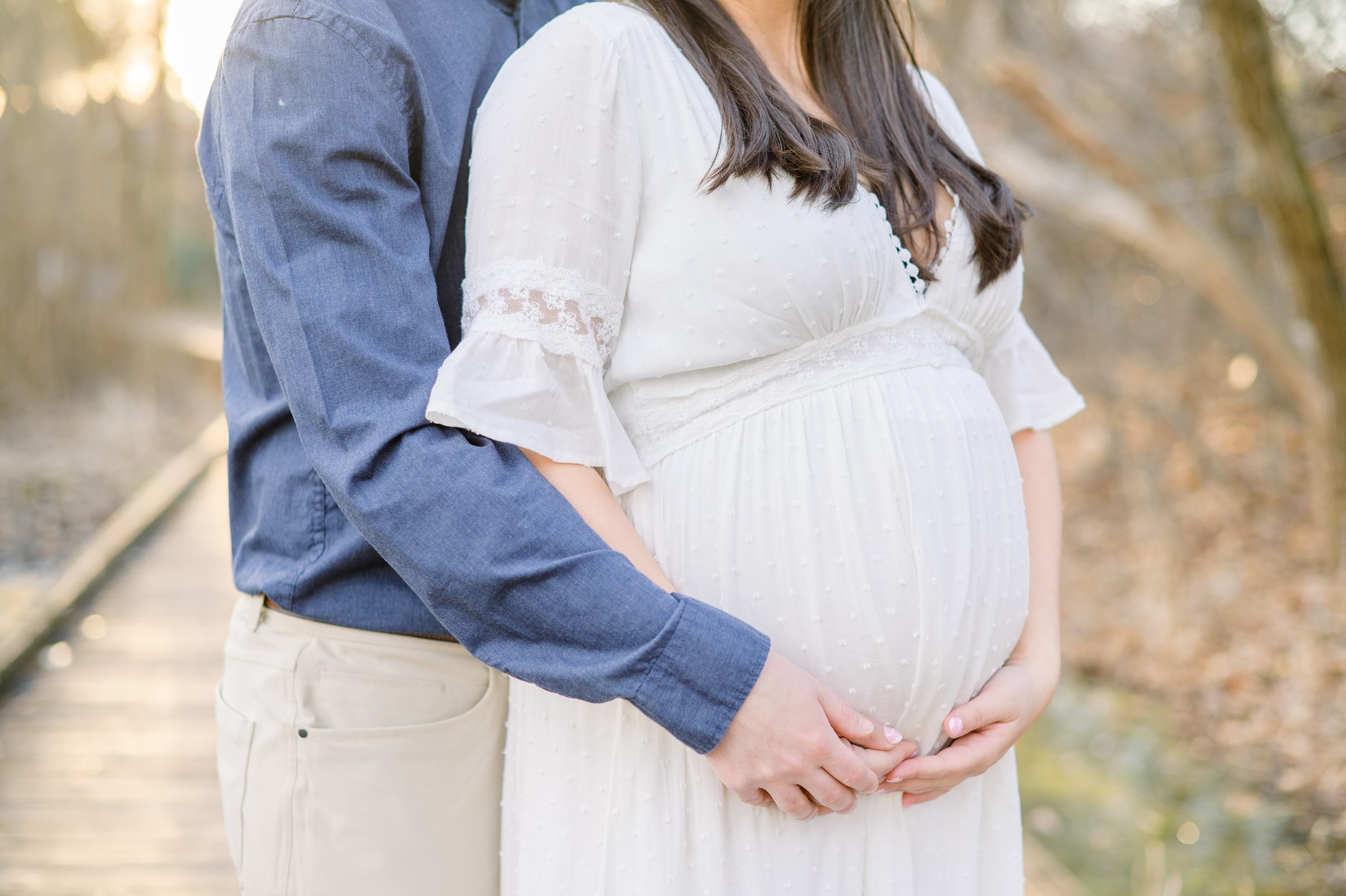 Abby and Nick's maternity session in Patterson Park in Baltimore County featuring a stunning golden hour and beautiful pink trees.