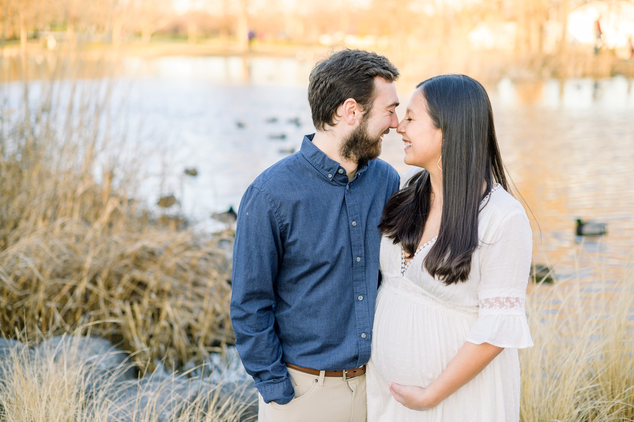 Abby and Nick's maternity session in Patterson Park in Baltimore County featuring a stunning golden hour and beautiful pink trees.