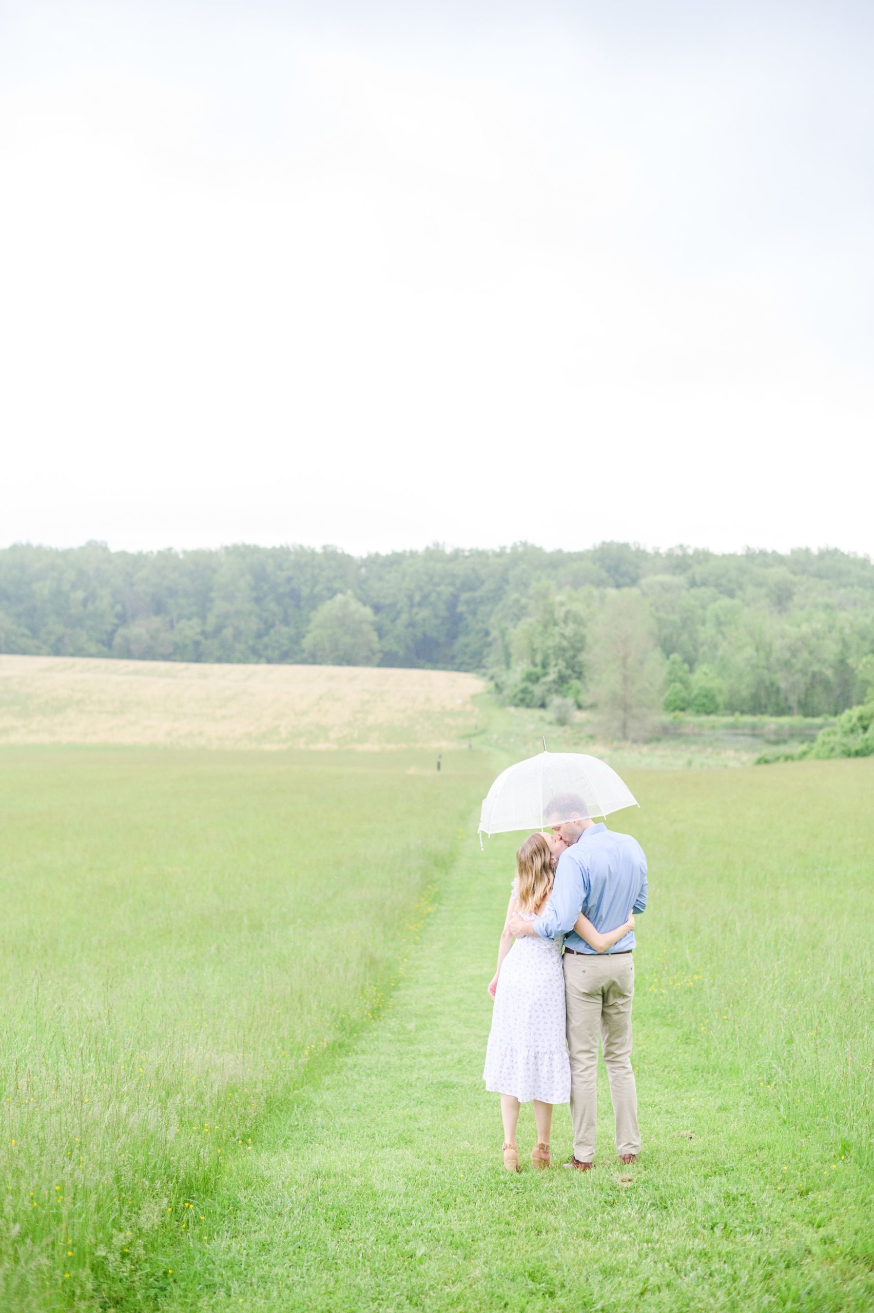 Engaged Couple poses in the fields near Belmont Manor during a rainy sunset engagement photographed by Baltimore Wedding Photographer Cait Kramer