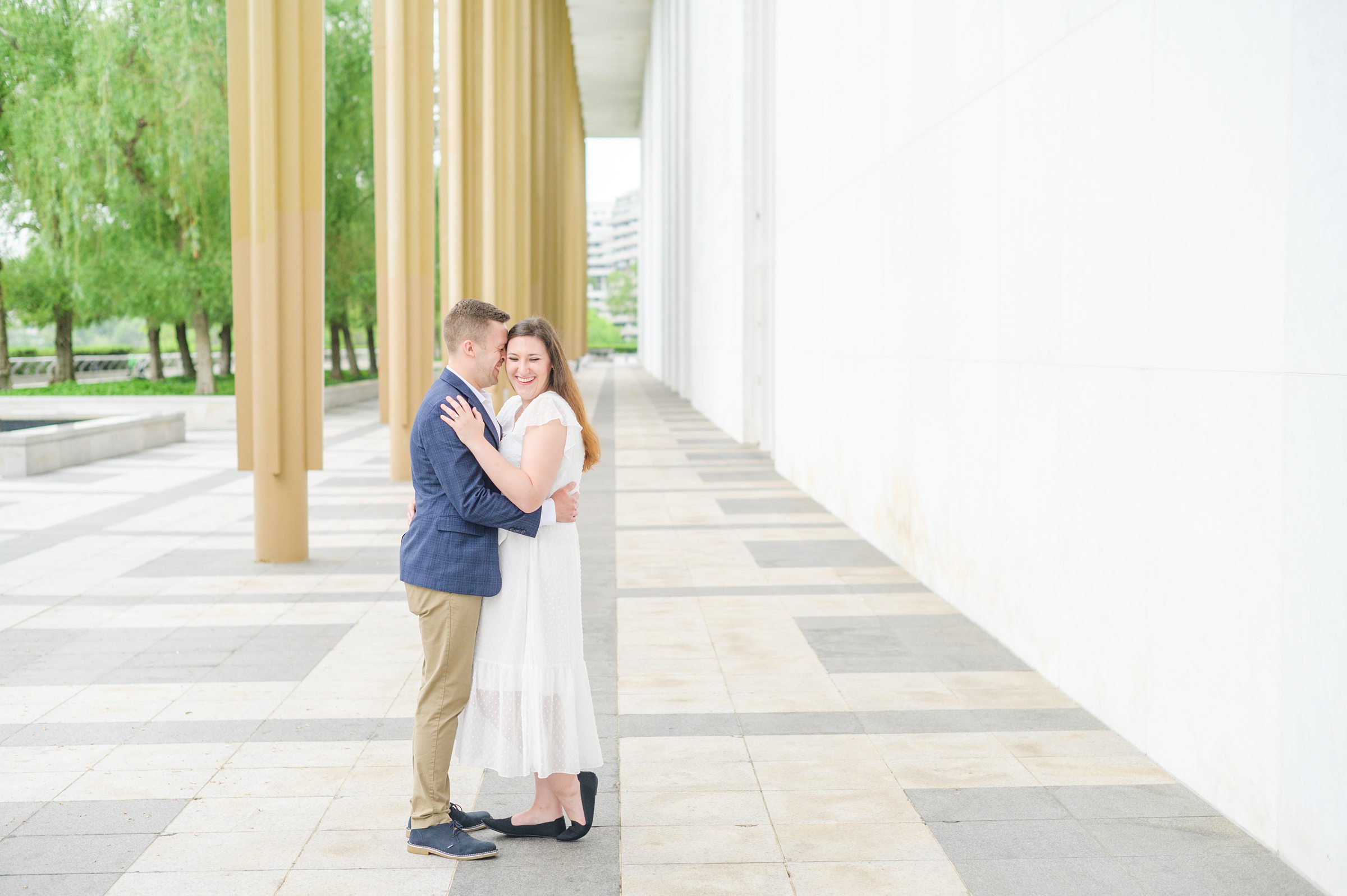 Engaged couple smiles near the Kennedy Center during engagement session at the Kennedy Center photographed by Baltimore Wedding Photographer Cait Kramer Photography