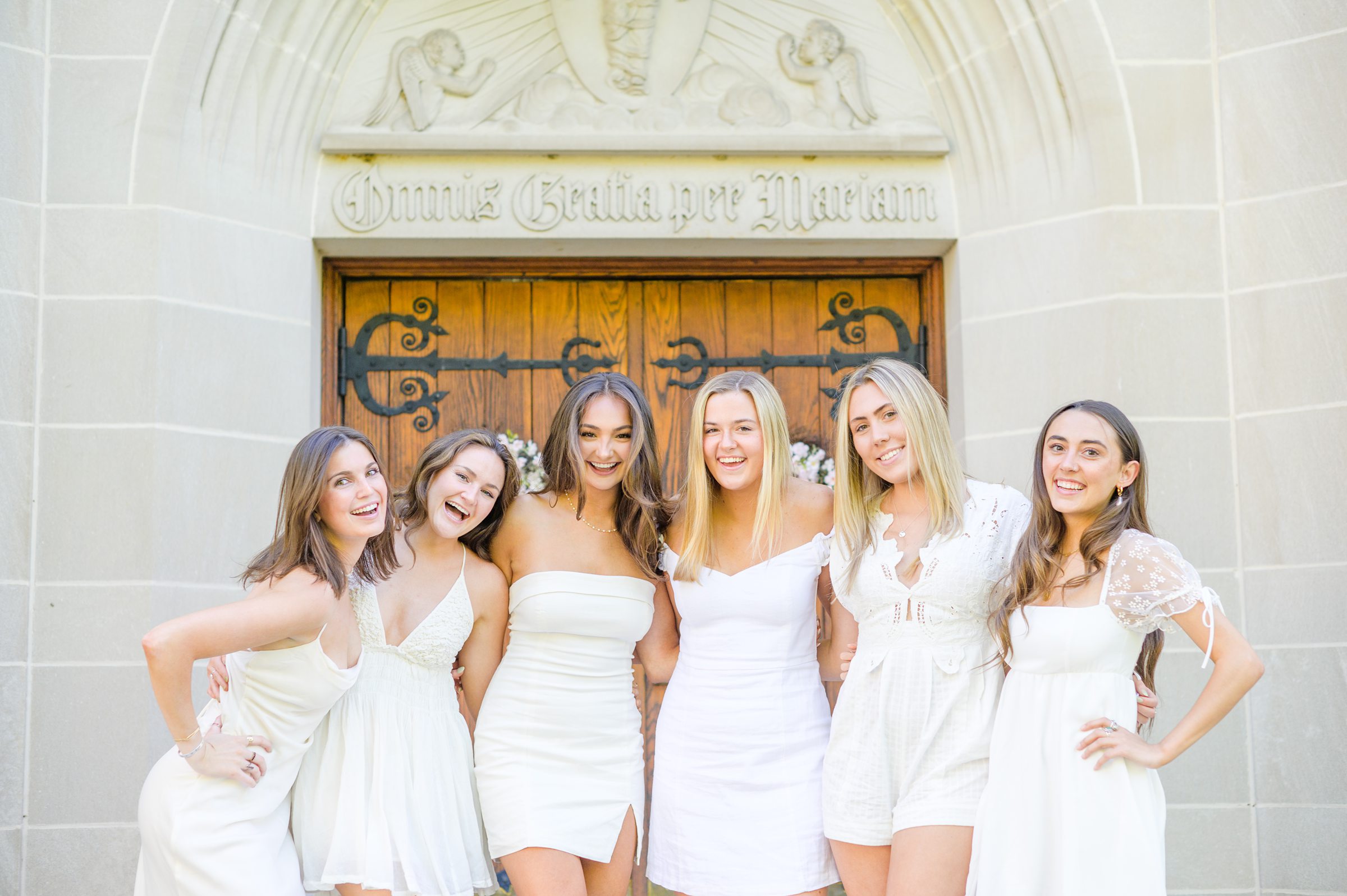 Loyola seniors pose on Loyola University Maryland's campus in graduation attire during Baltimore Grad Session photographed by Cait Kramer