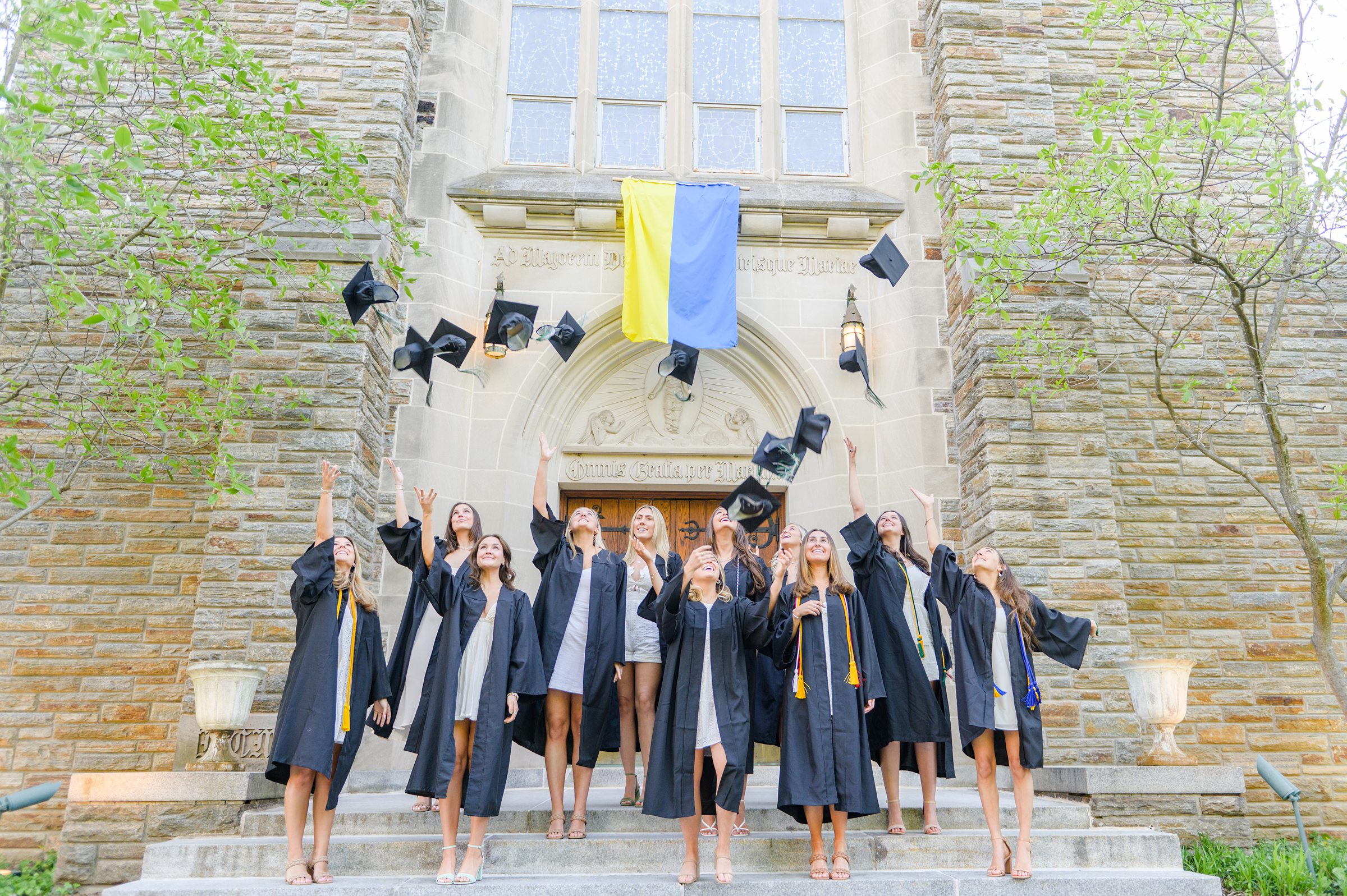 Loyola seniors pose on Loyola University Maryland's campus in graduation attire during Baltimore Grad Session photographed by Cait Kramer