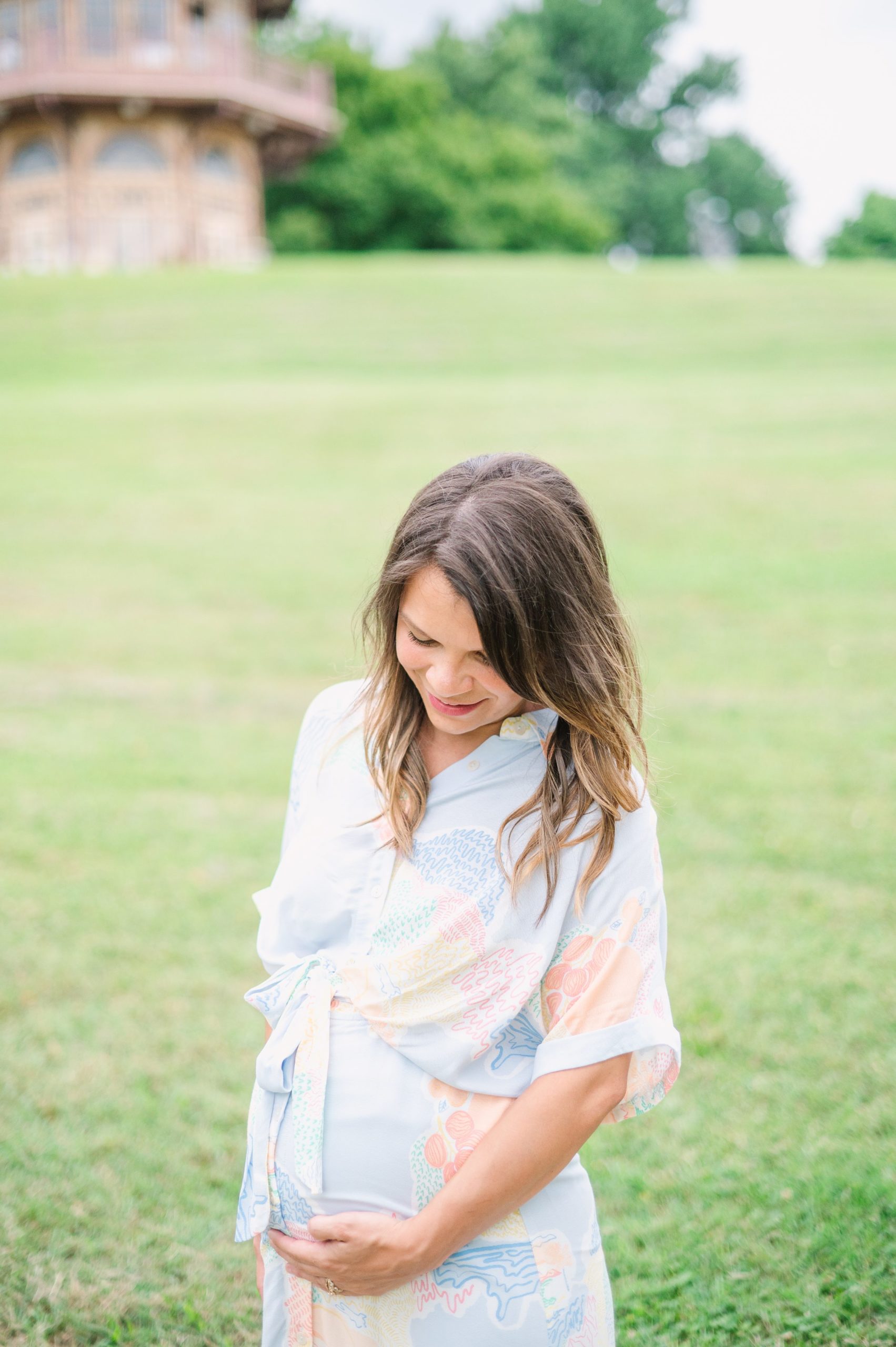 Expecting couple smiles during Patterson Park maternity session photographed by Baltimore Photographer Cait Kramer.