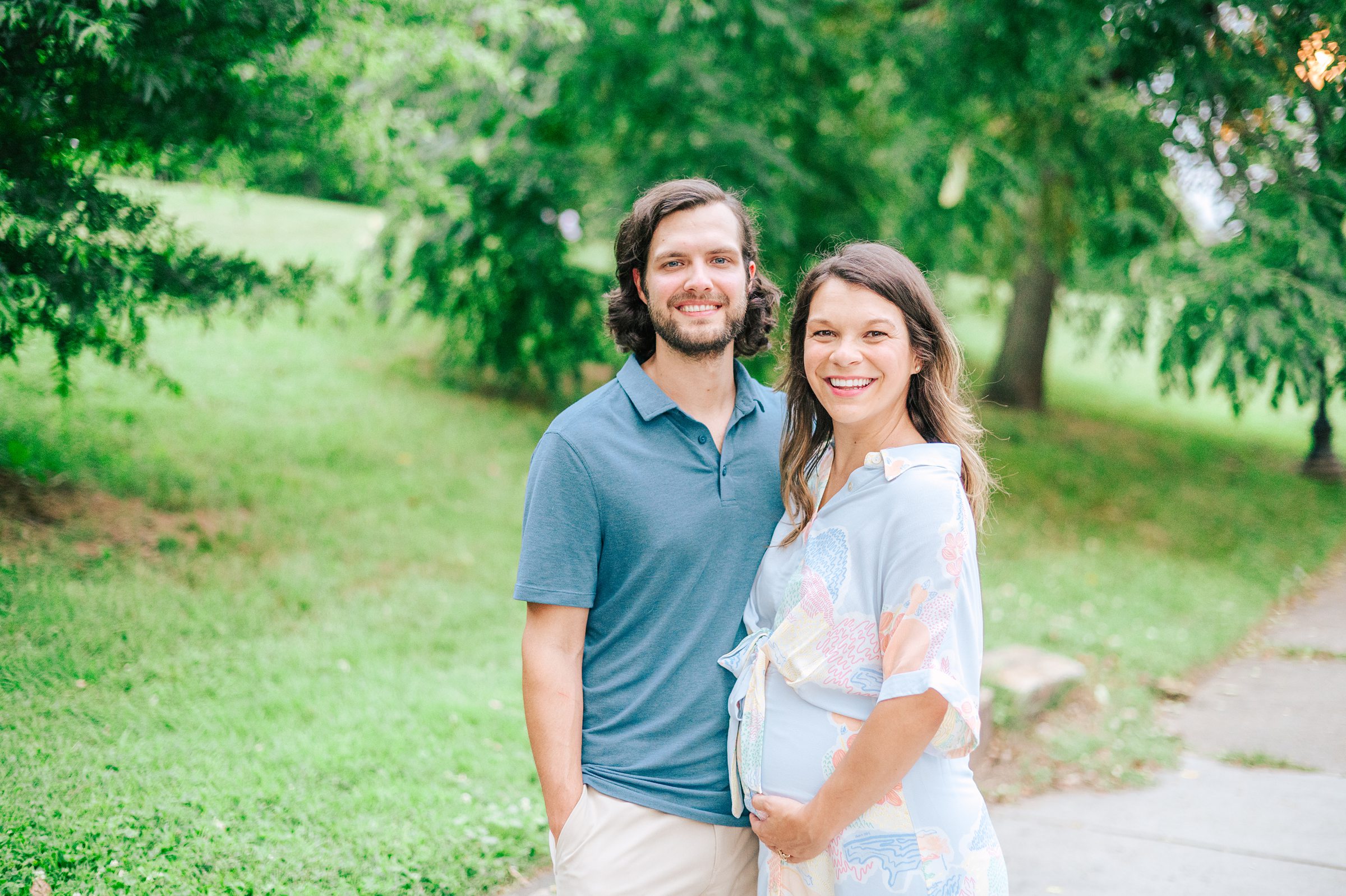 Expecting couple smiles during Patterson Park maternity session photographed by Baltimore Photographer Cait Kramer.